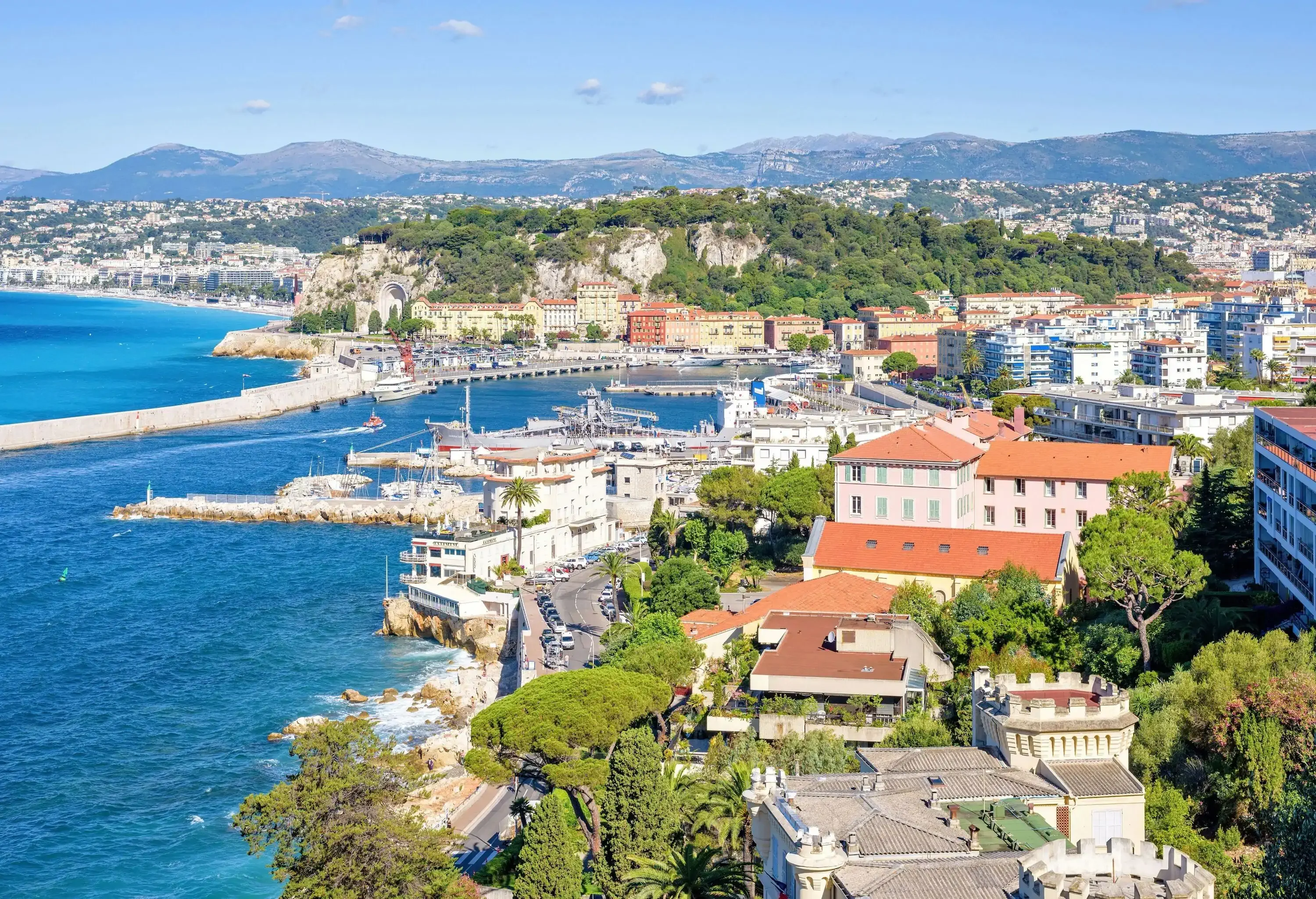 Urban landscape of a city with a road along a steep and rocky coastline.