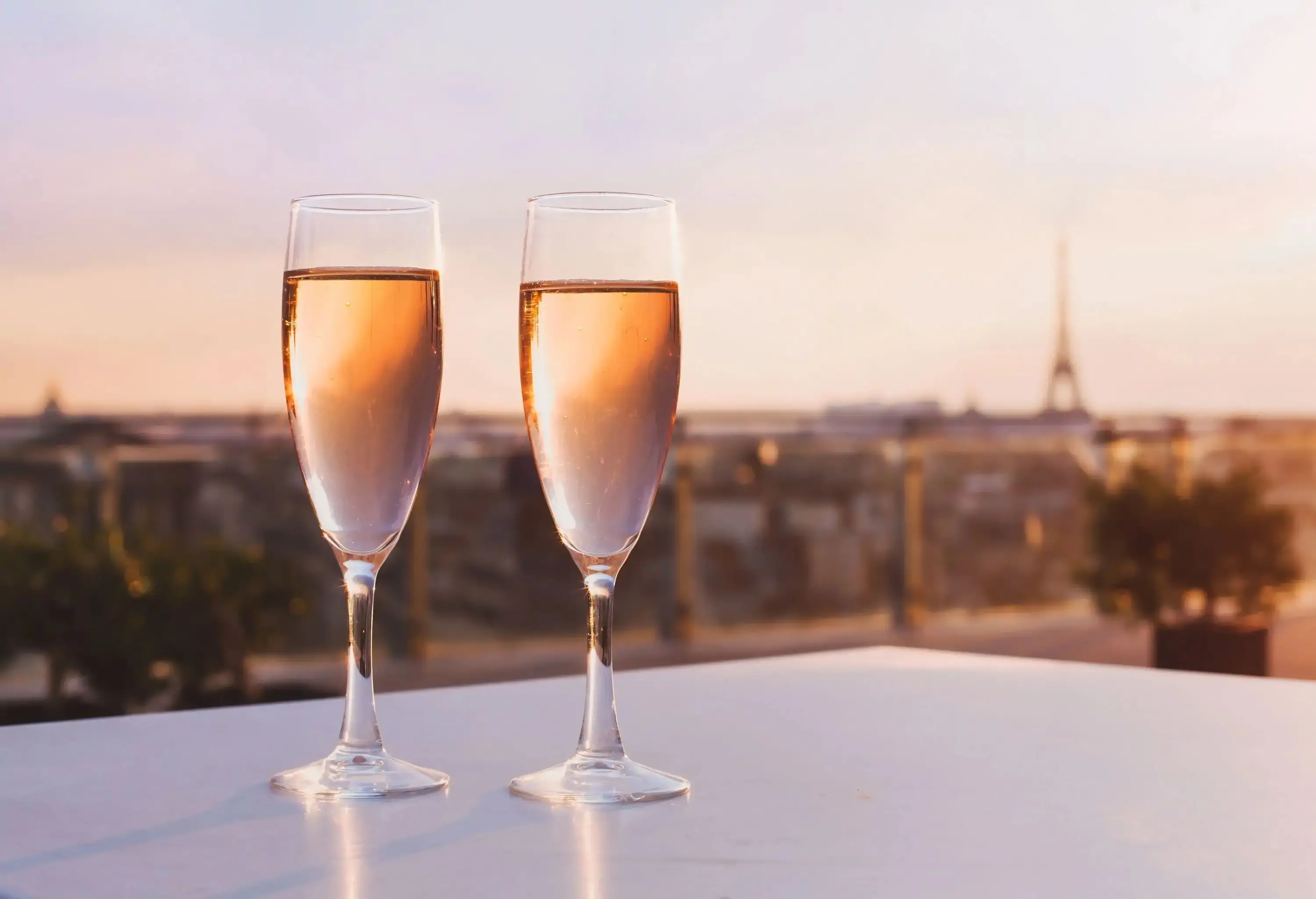 Two glasses of champagne on a white table.