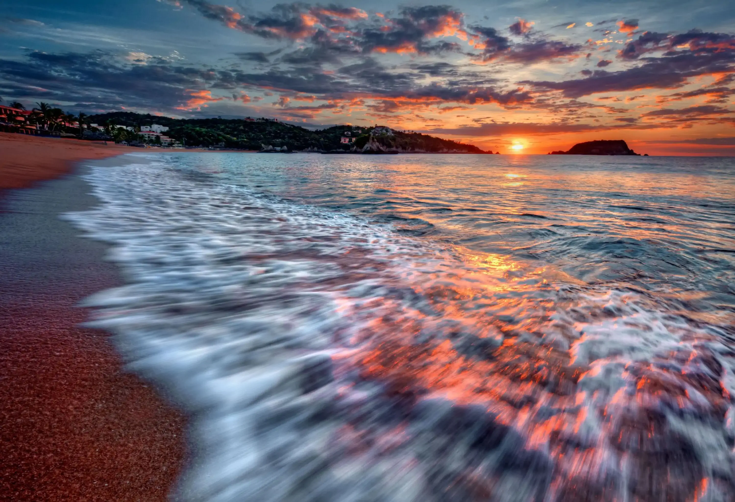 Waves lapping on the shore as the dark clouds wiping out the remaining light of the day.