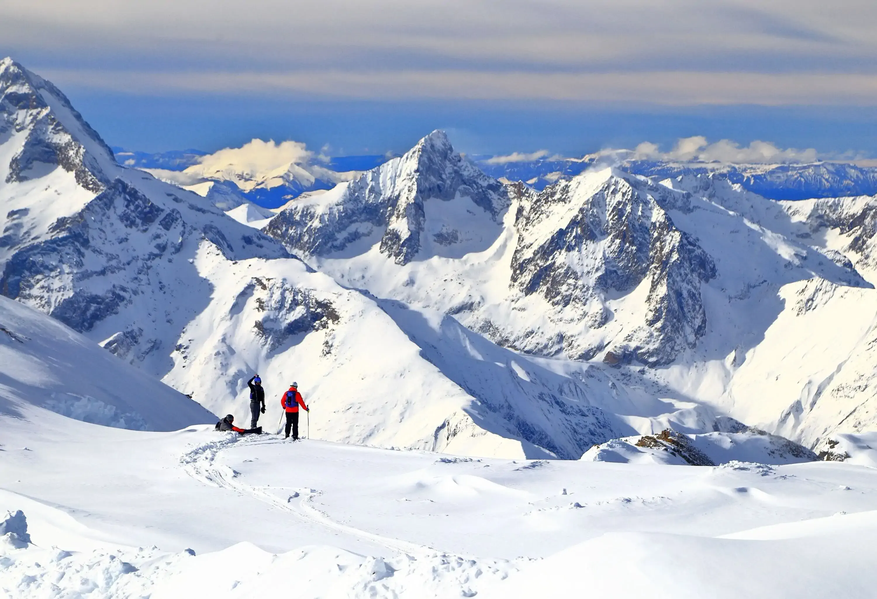 Thee skiers taking a rest on a slope in the Alps.