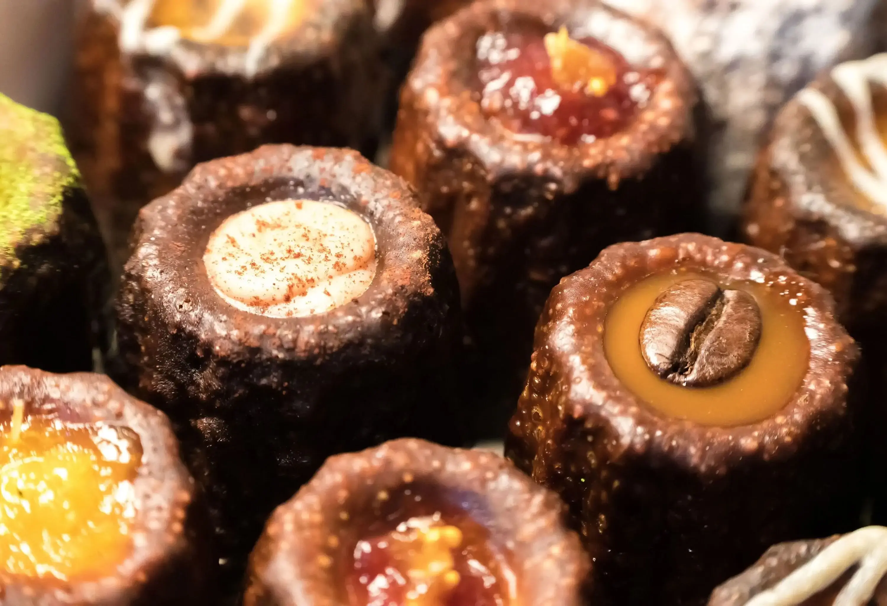 Chocolate canelés with jam, caramel, and custard filling.
