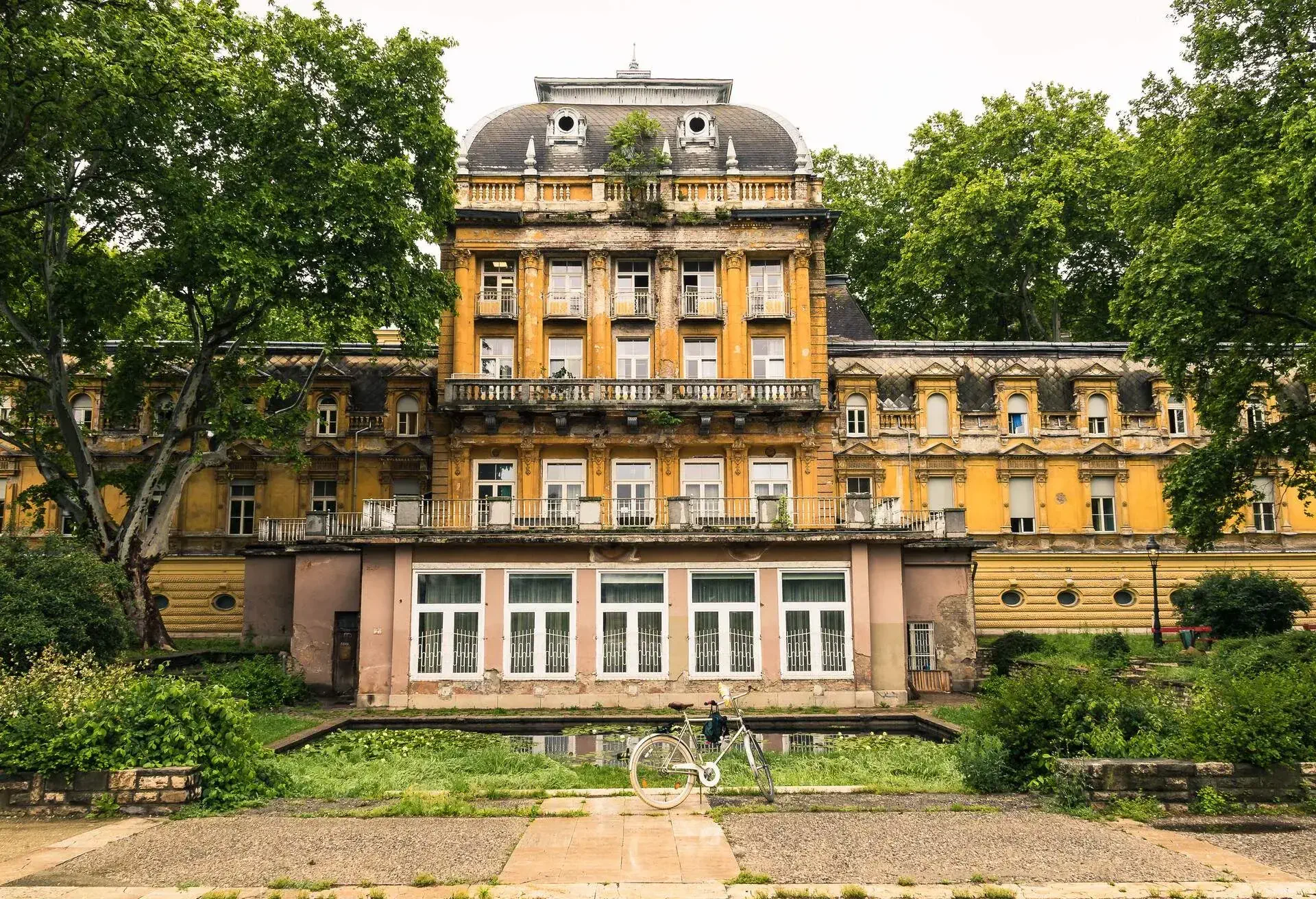 1800-squaremetre park with trees, many of wich are centuries old and the facade of the historical Lukacs Termal Bath building with the medicinal bath section and the indoor swimming pool in Budapest.; Shutterstock ID 1424896898