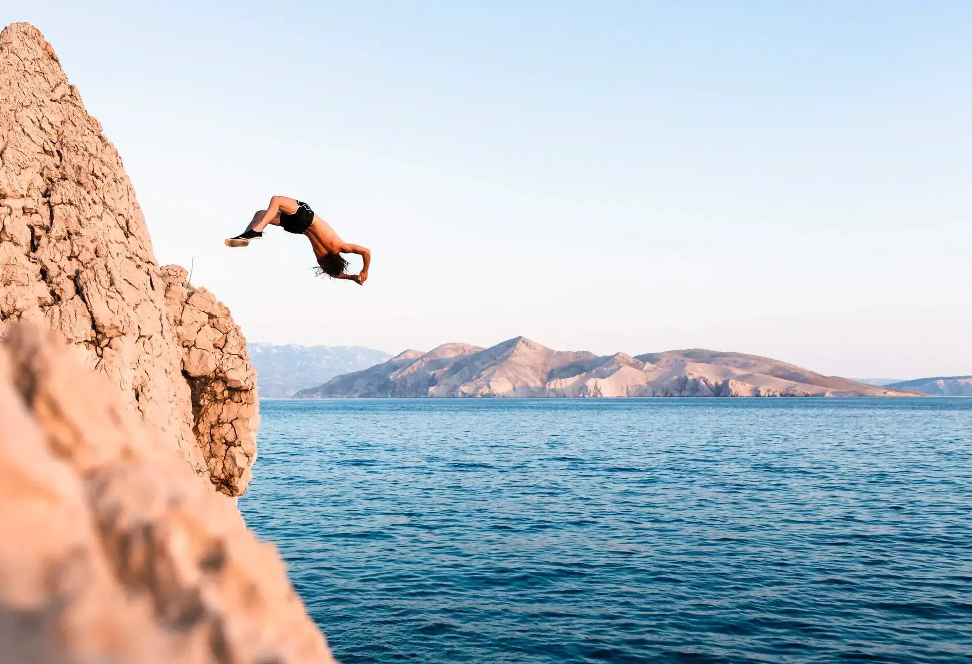 DEST_CROATIA_KRK_THEME_BEACH_MAN_JUMP_GettyImages-1255088858