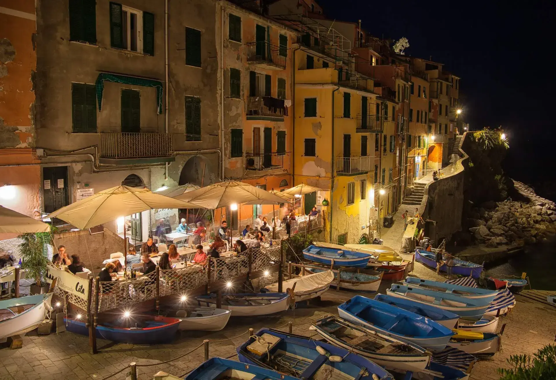 People enjoying restaurants in the evening at the fisherman's harbour in Riomaggiore in Cinque Terre,Italy