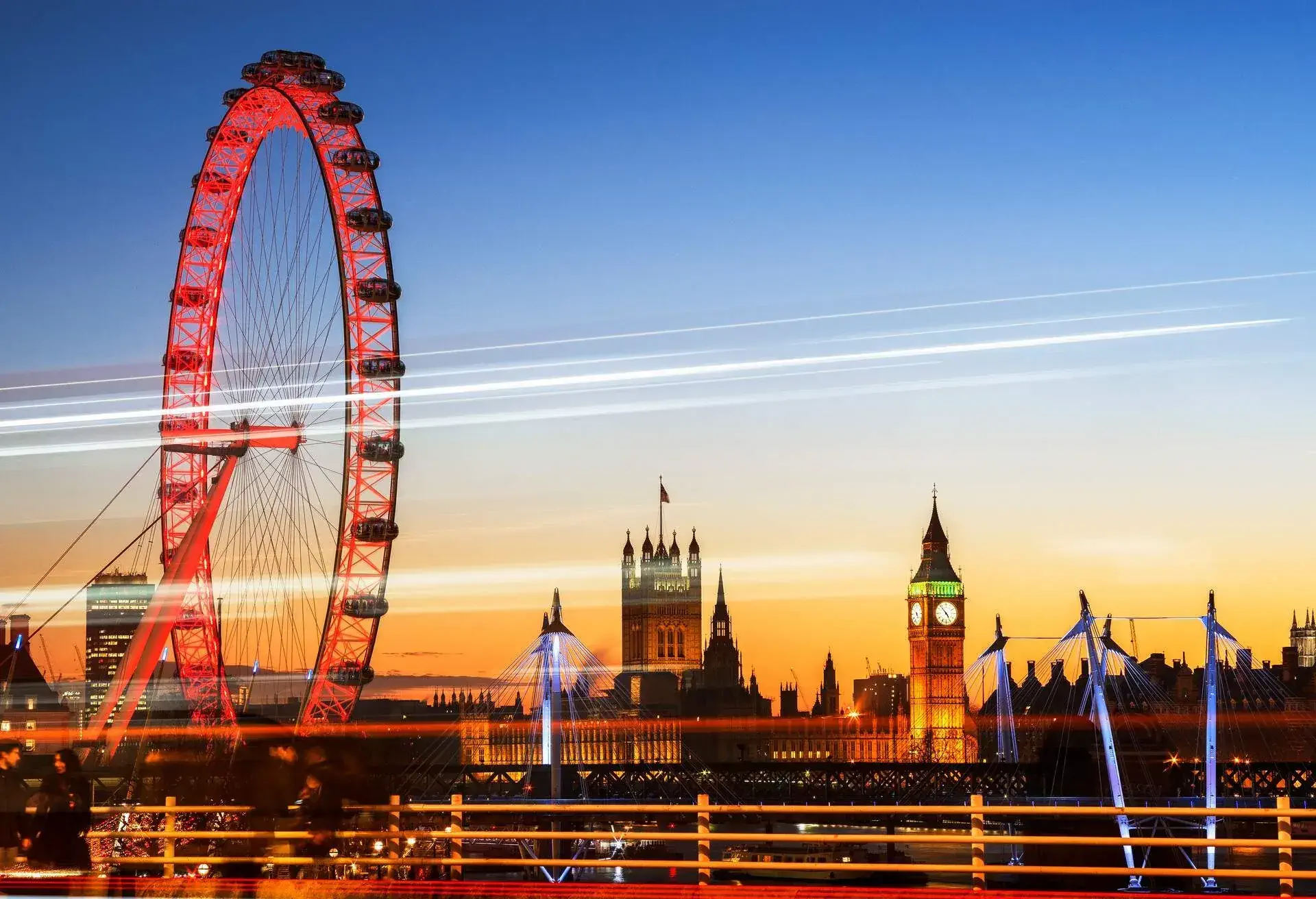 UK, London, long exposure of the Houses of Parliament and the Millennium Wheel with traffic trails, illuminated at twilight