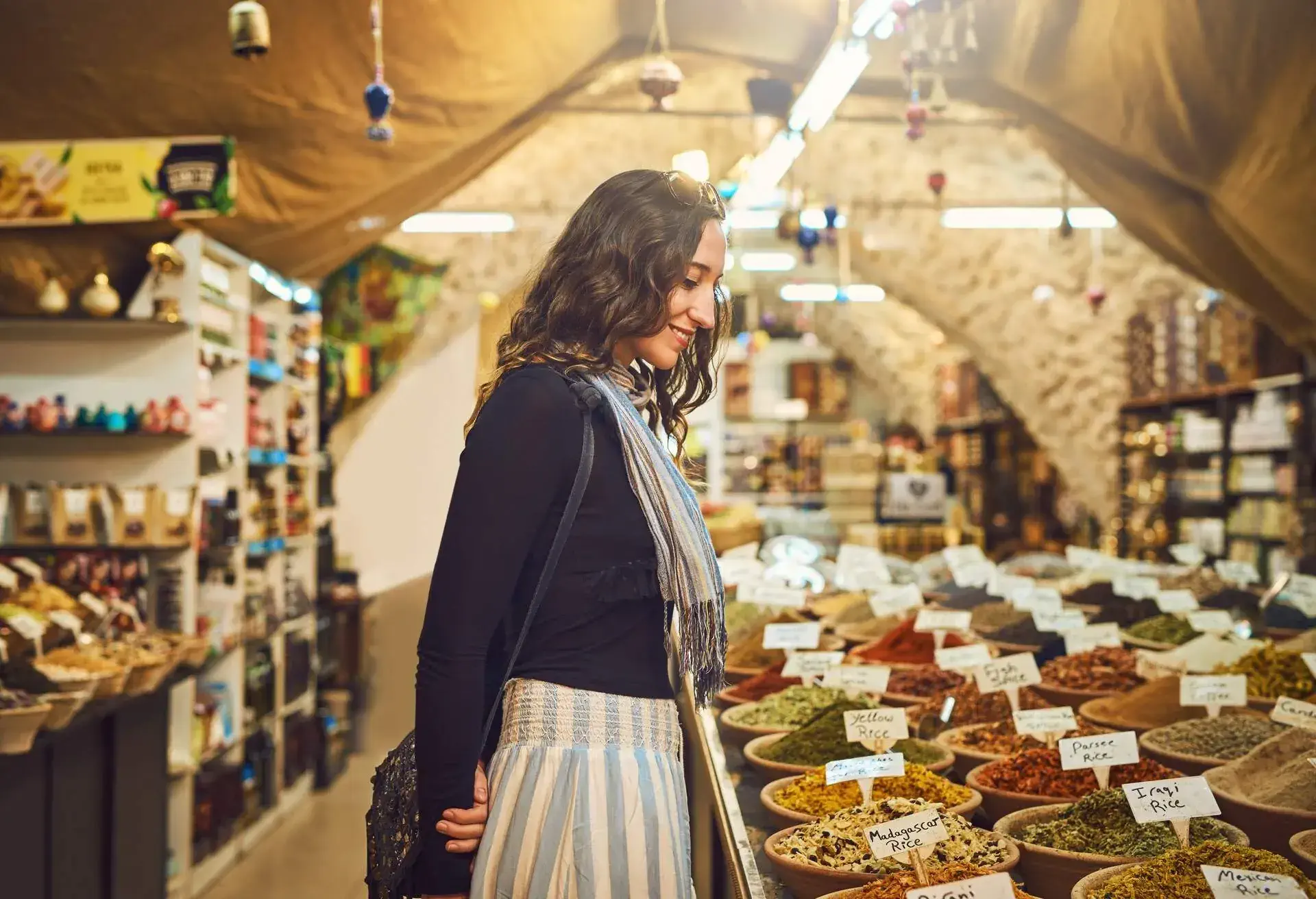 Shot of a young woman shopping for spices at a local market stall