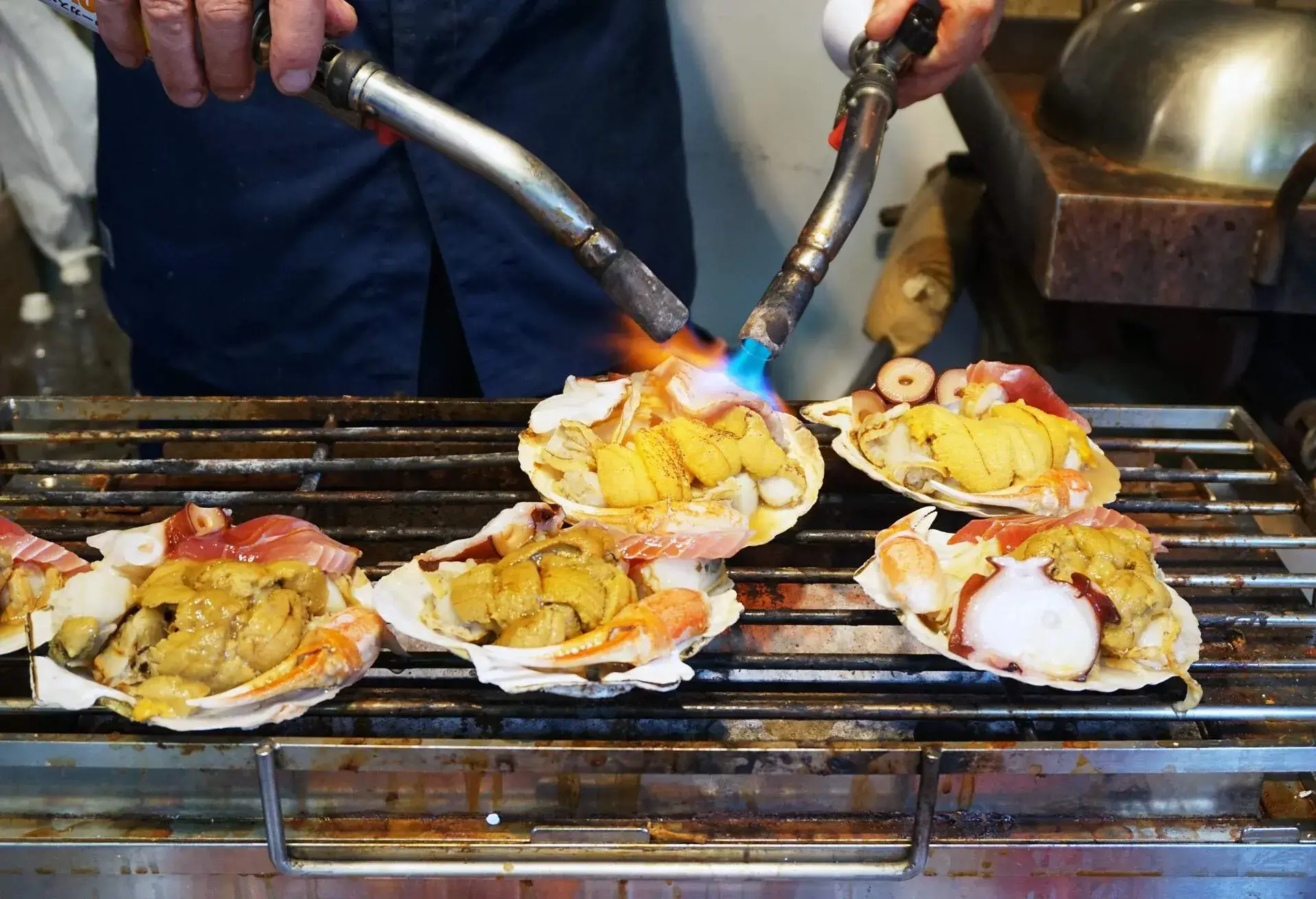 Japanese street food, grilled seafood on seashell at Tsukiji Fish Market, Tokyo, Japan. ; Shutterstock ID 606264968