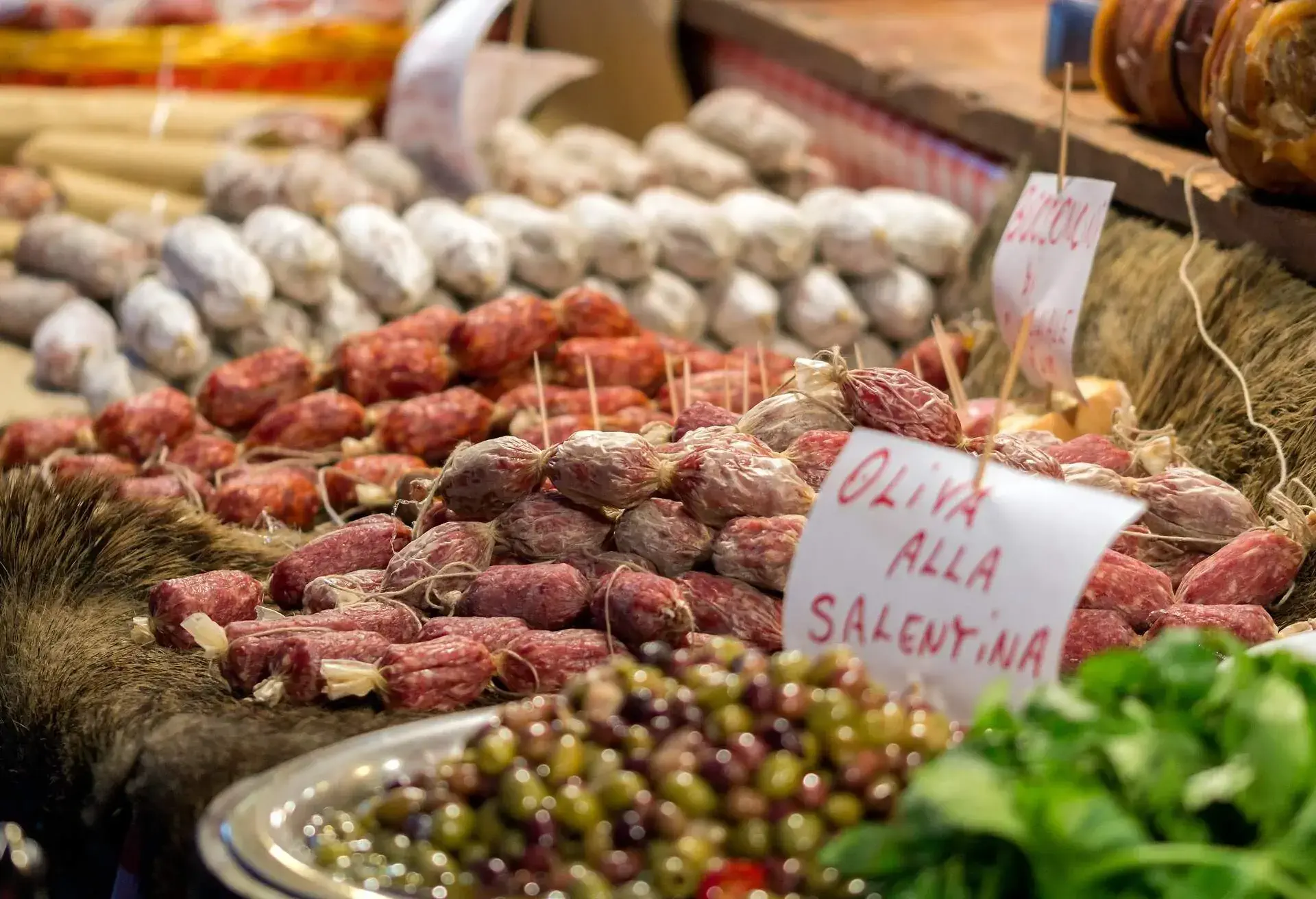 Italian market stall with wild boar salami and olives