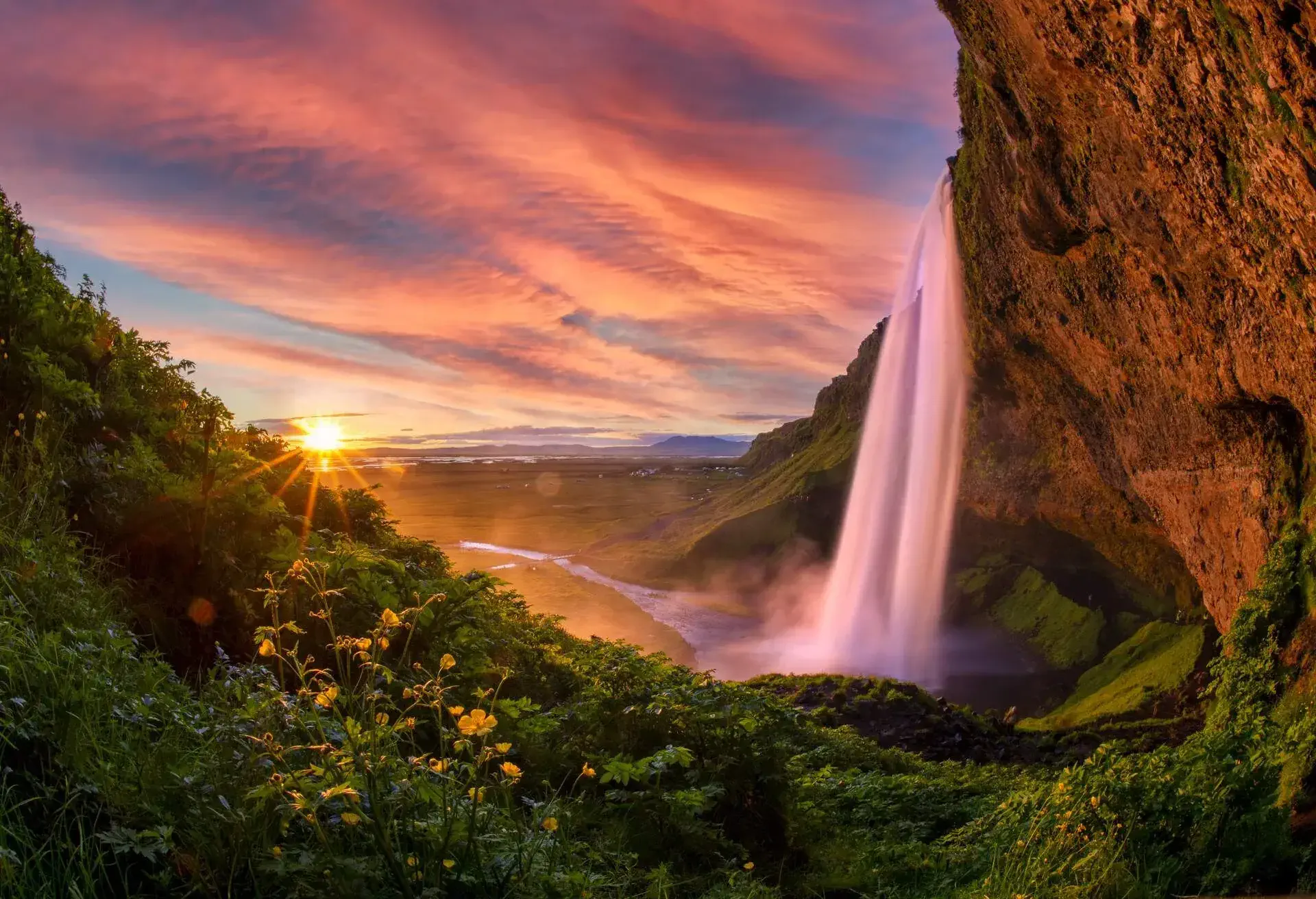 Sunset Scene of Seljalandsfoss is one of the most beautiful waterfalls on the Iceland. It is located on the South of the island. With a rainbow.