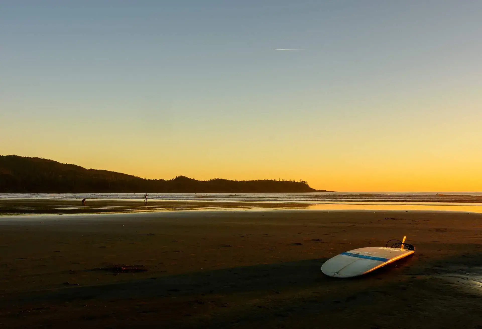 A surfboard is located on a beach on Vancouver Island