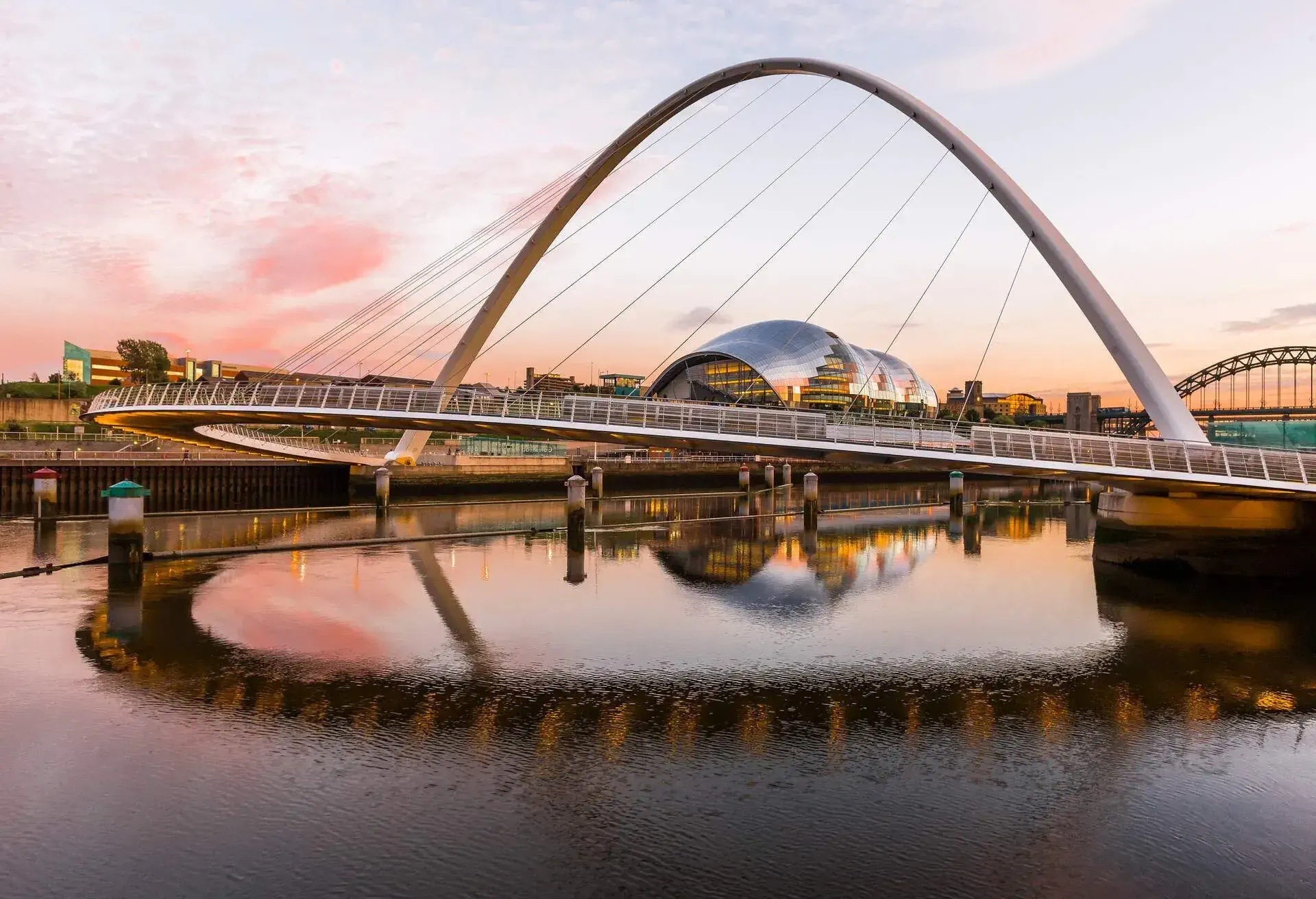 The Gateshead Millennium Bridge (Keith Brownlie, Wilkinson Eyre Architects) between Gateshead and Newcastle upon Tyne and the River Tyne at the sunset, the Sage Gateshead (Norman Foster architect) on the background