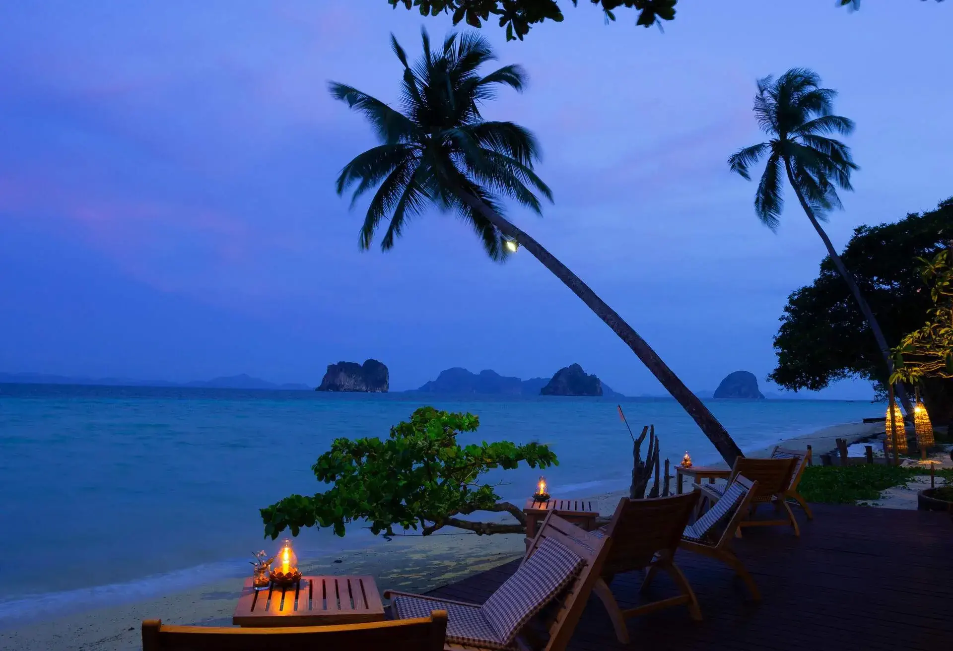 Deserted tavern with tables and chairs on the seafront overlooking the sea in spring evening,Light before sunrise at Koh(island) Ngai,Trang Province,Thailand.
