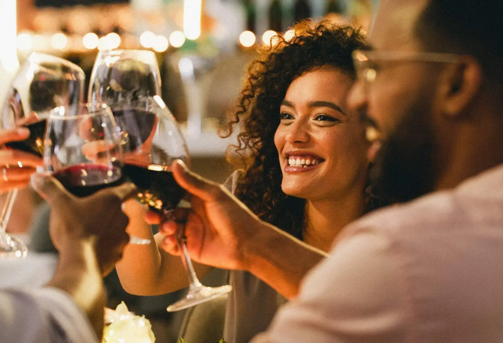Cropped shot of a group of cheerful young friends making a toast while dining together in a restaurant