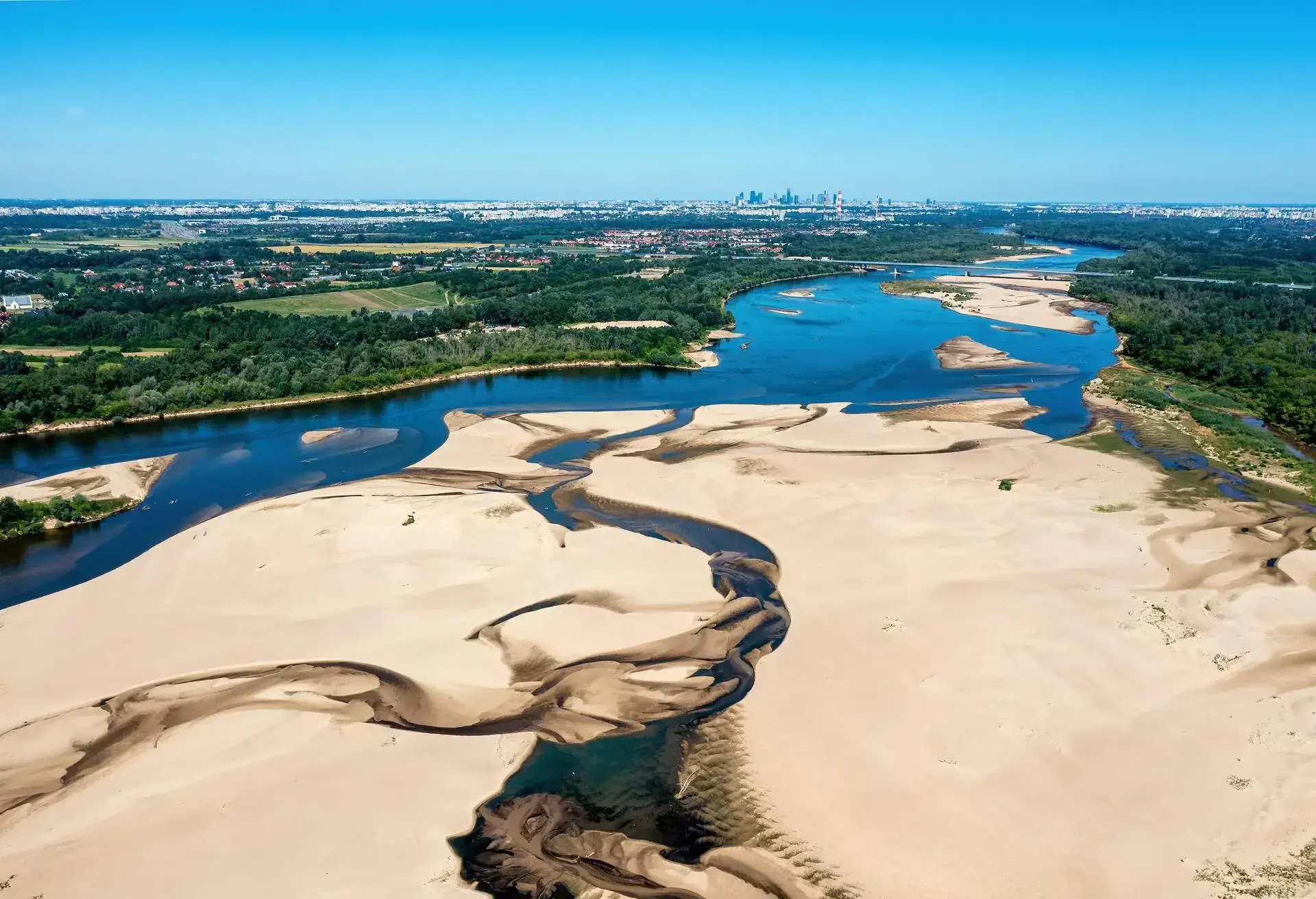 Low water level in Vistula river, effect of drought seen from the bird's eye perspective. City Warsaw in a distance.