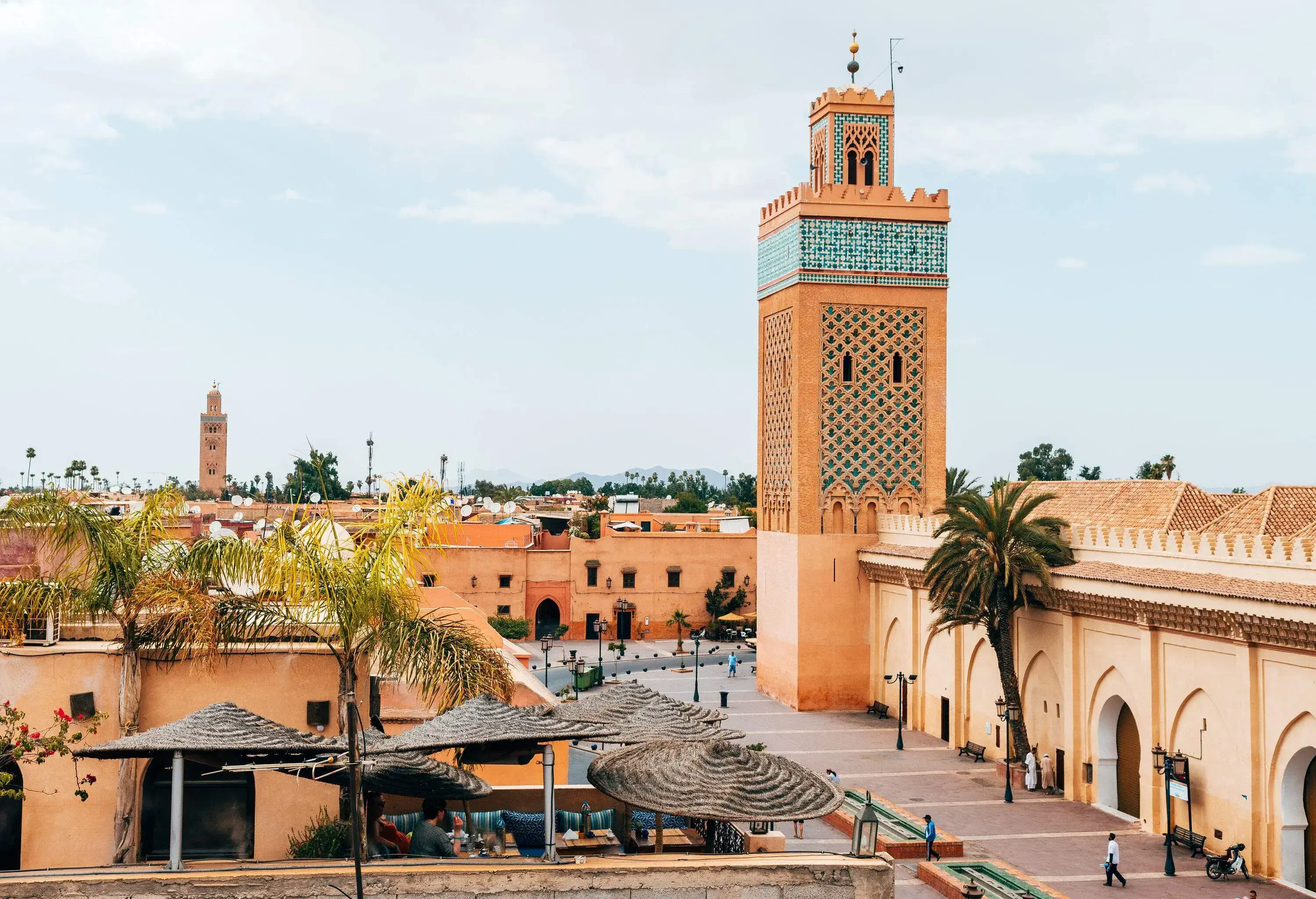 From the vantage point of a rooftop in Marrakech's old medina city, one can see a picturesque view of a nearby tower.