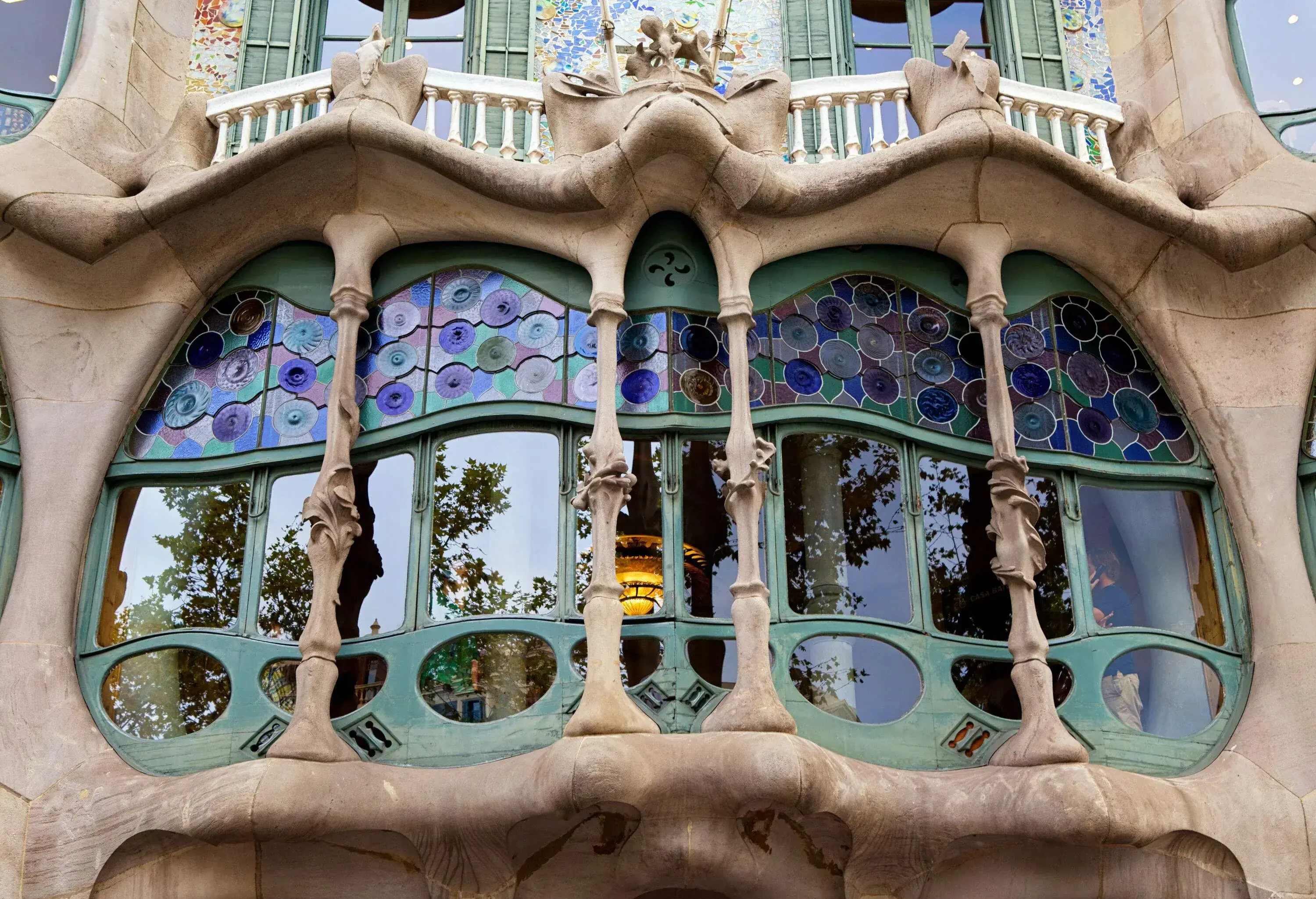 A rounded window with stained glass and carved pillars.