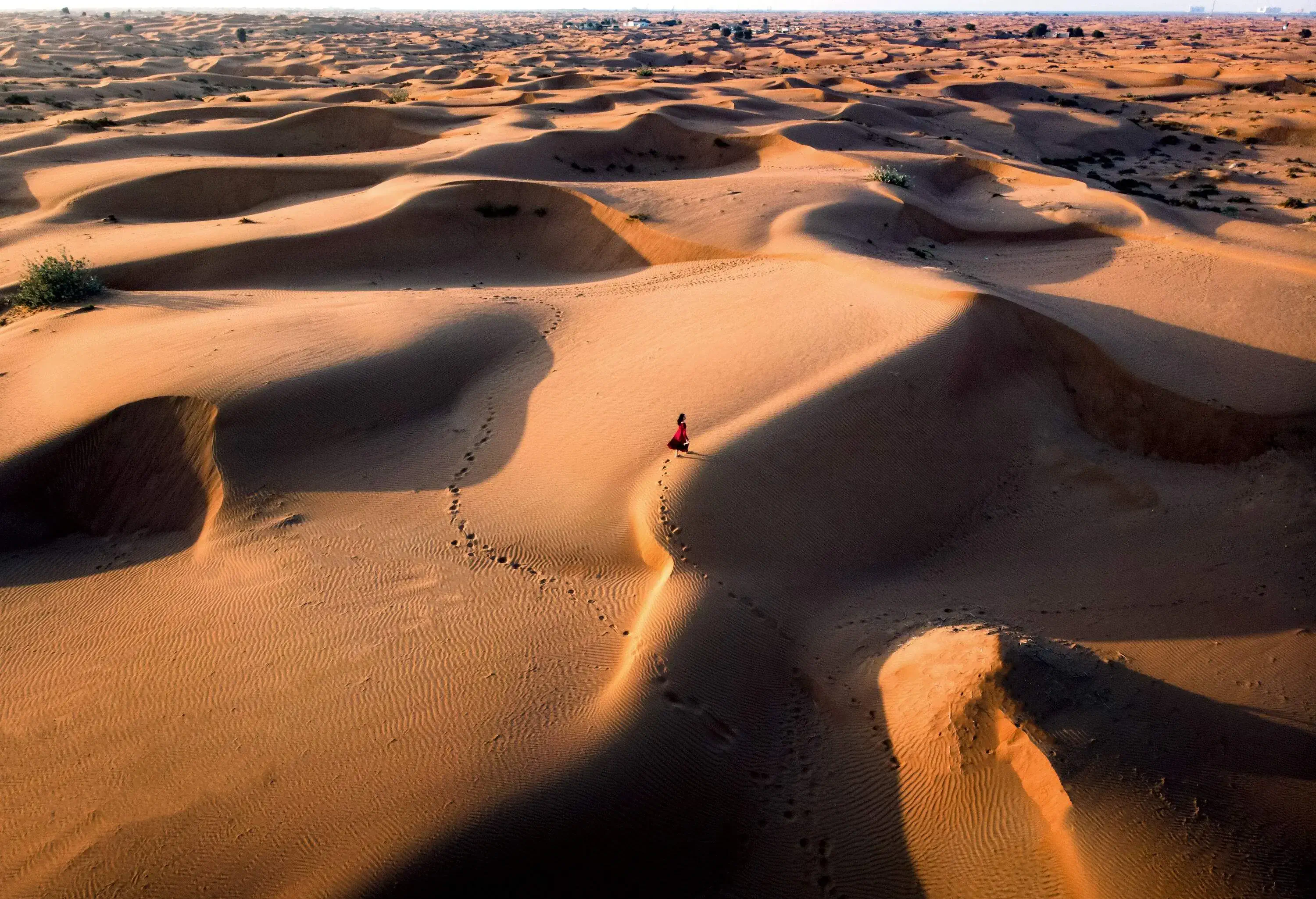 Woman walking in the desert during sunset aerial view