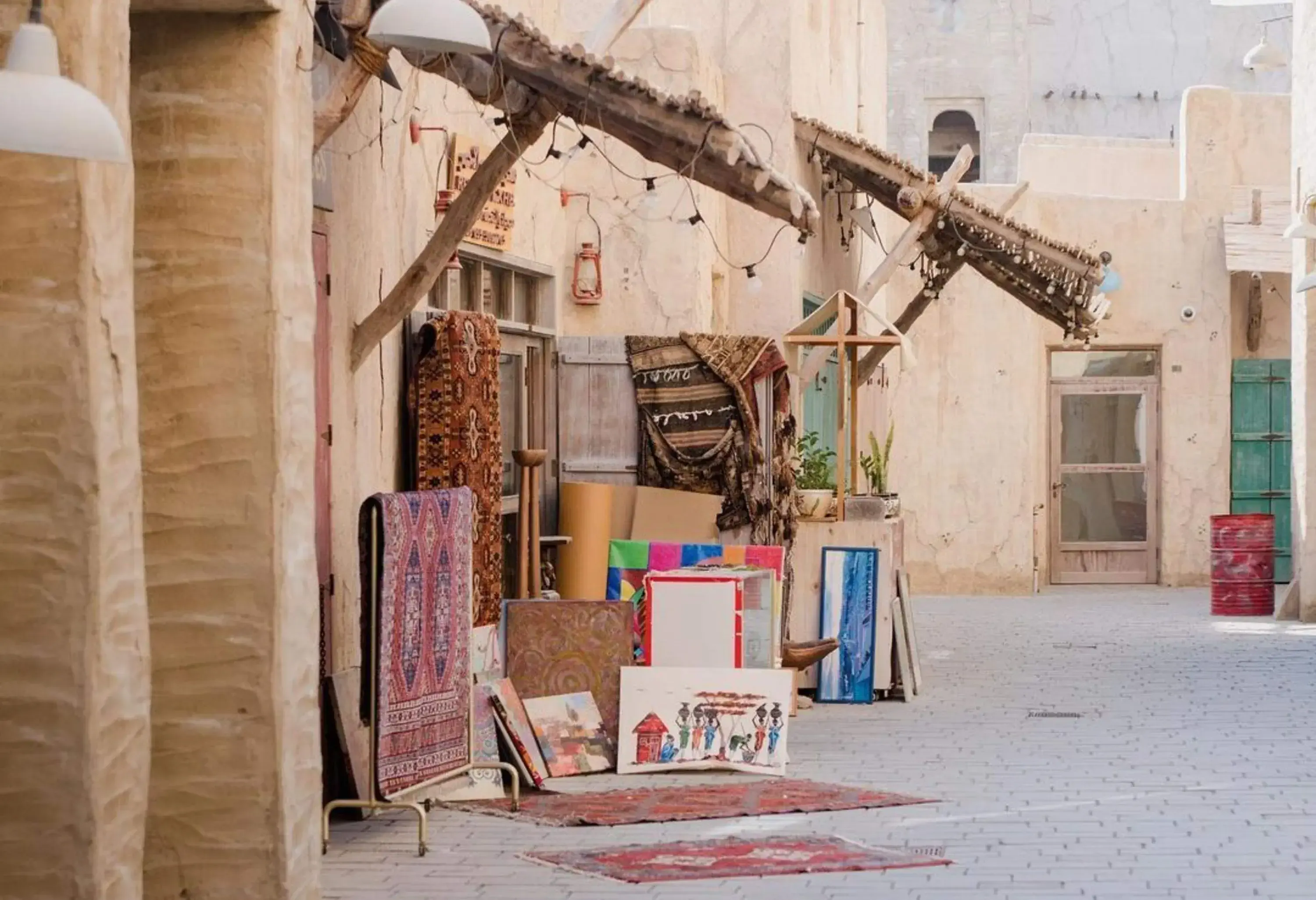 A shop along a street with displays of paintings and colourful carpets.