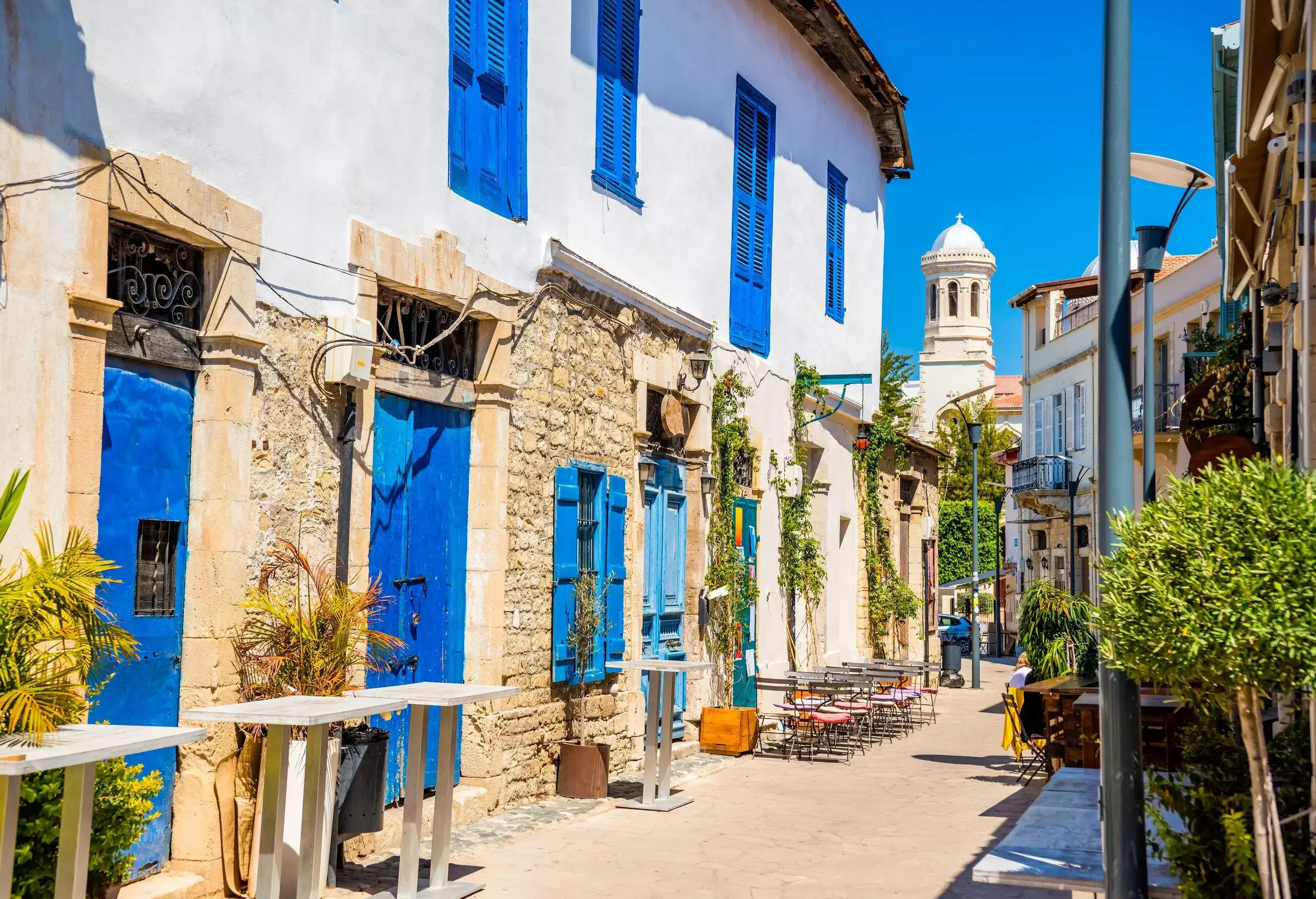 A street in a neighbourhood of houses with blue doors and blue window frames.