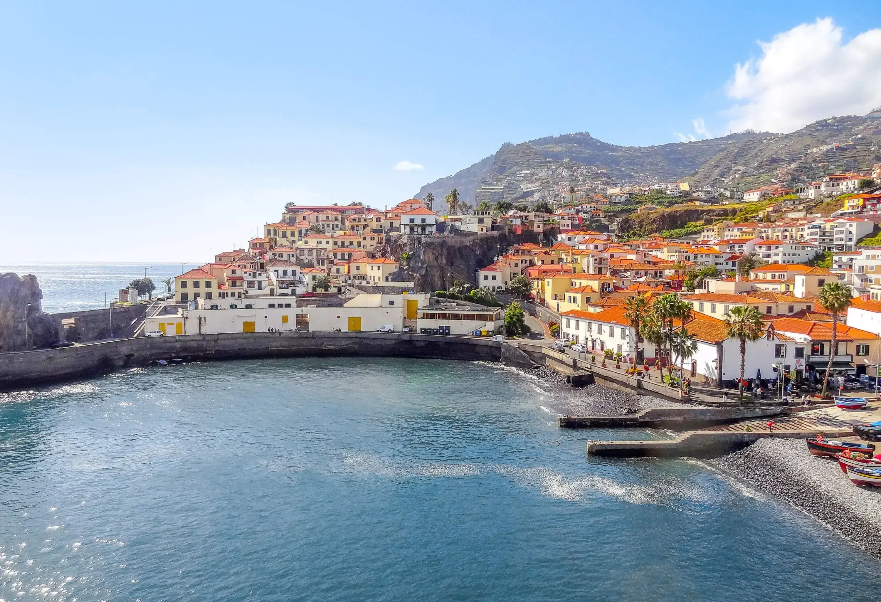 A small harbour surrounded by beautiful architecture on the coast and across the hillsides.