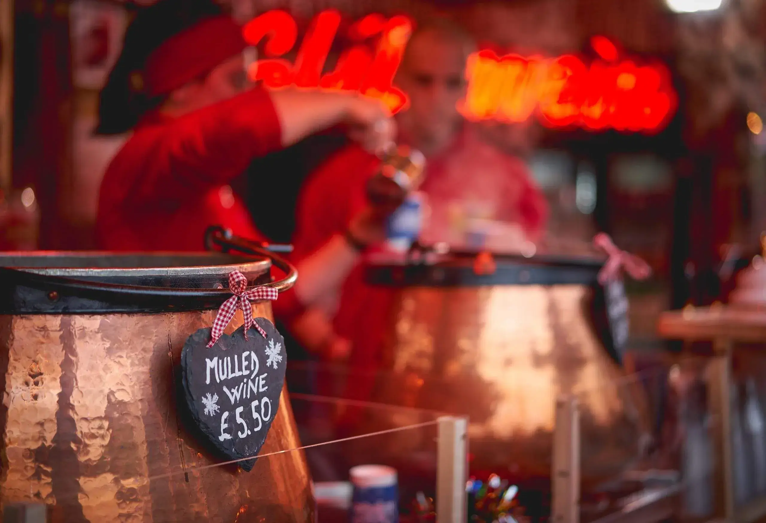 Pots de vin chaud dans un stand sur un marché de Noël.