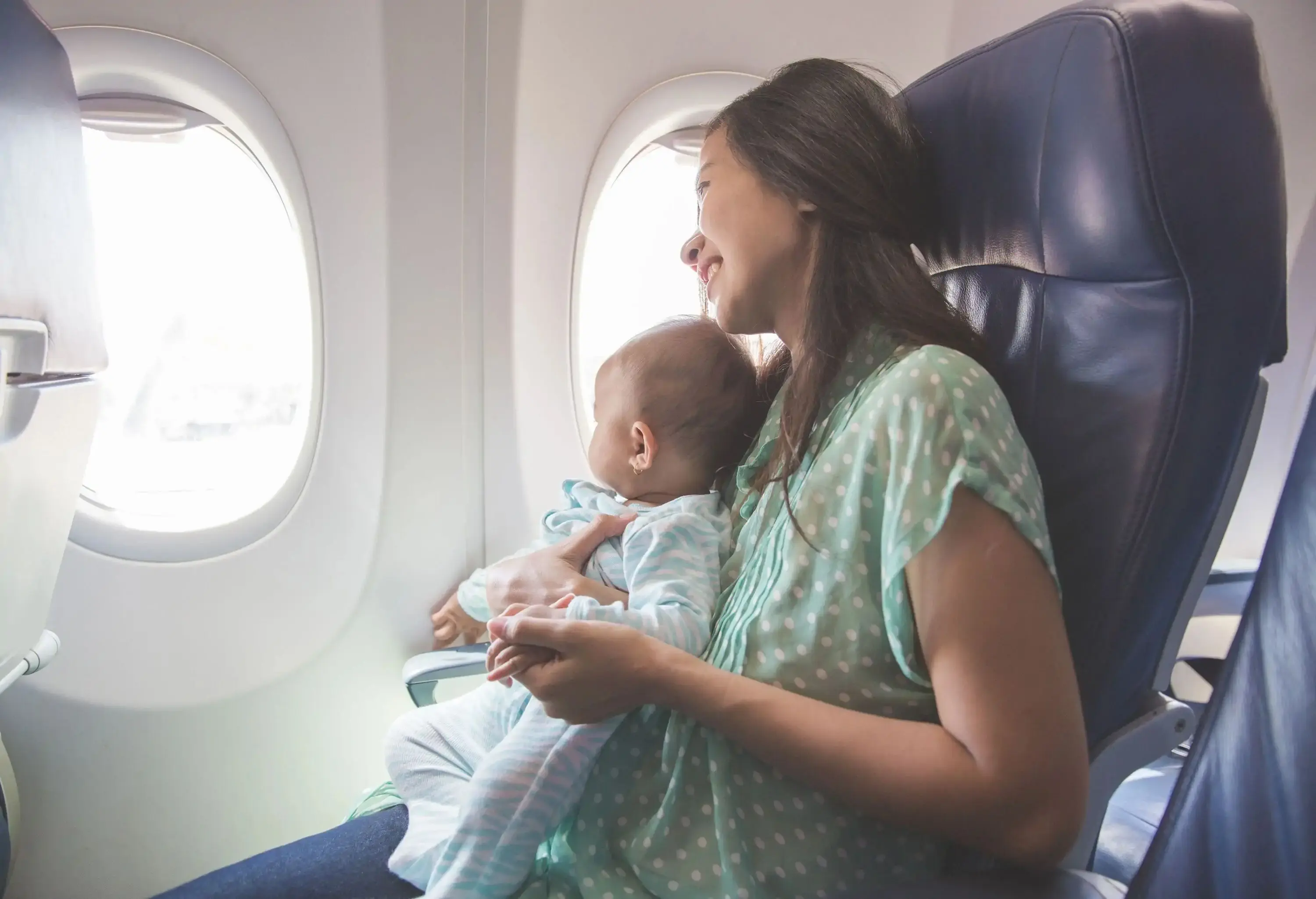 A baby on mother's lap sitting on a plane
