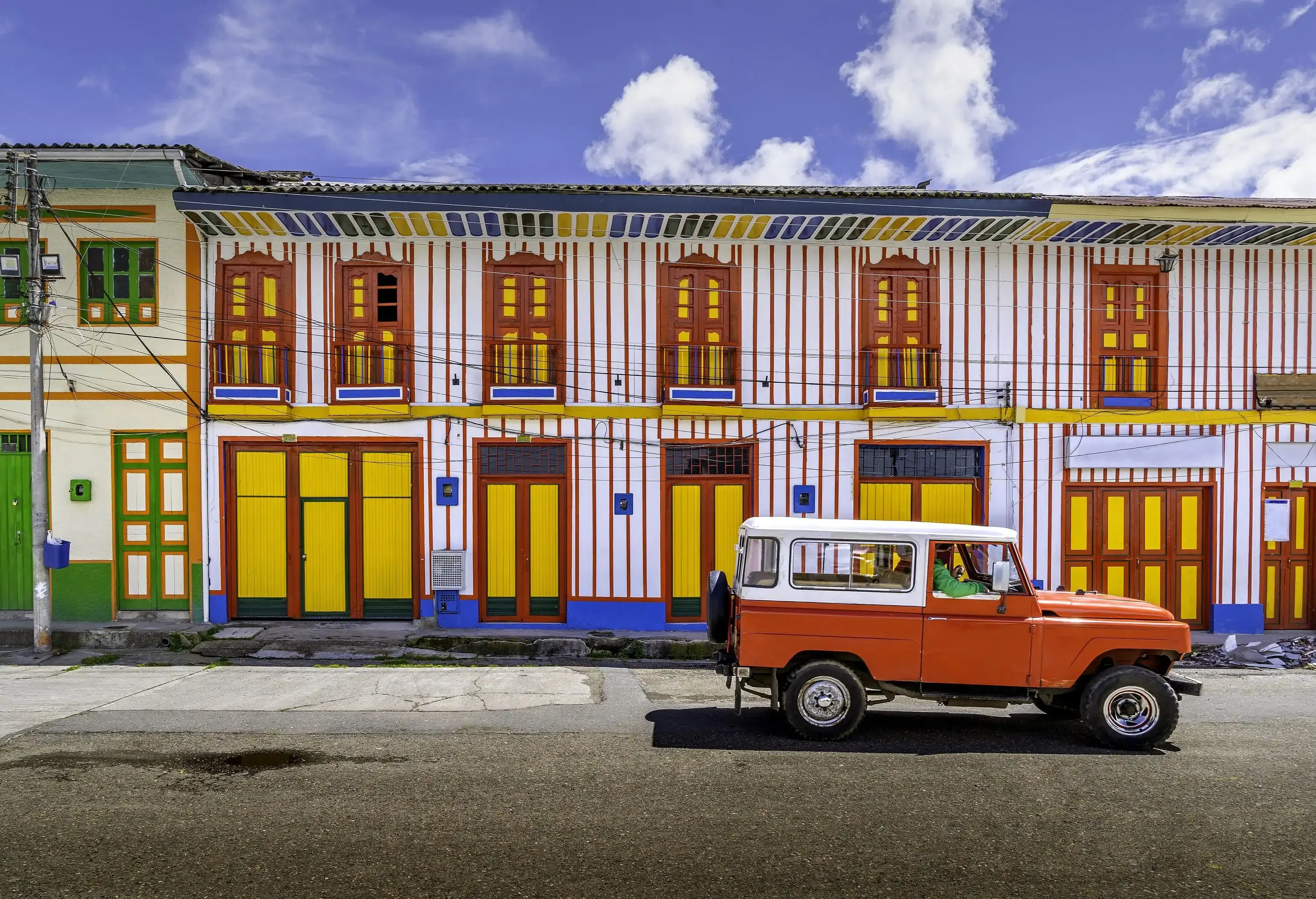 A car passing on the colourful street of Tolima Colombia the little town in a sunny day.