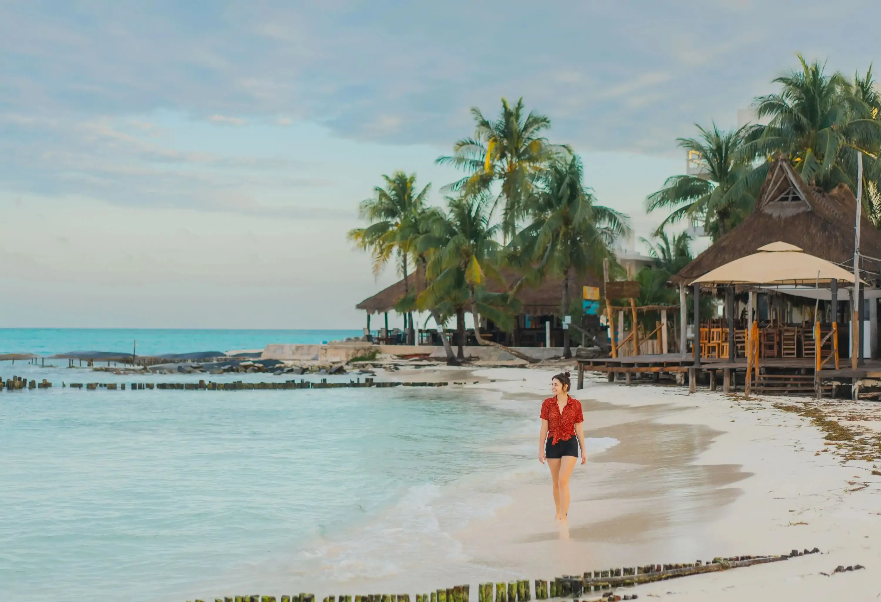 Young Caucasian woman walking on the of seaside on Isla Mujeres