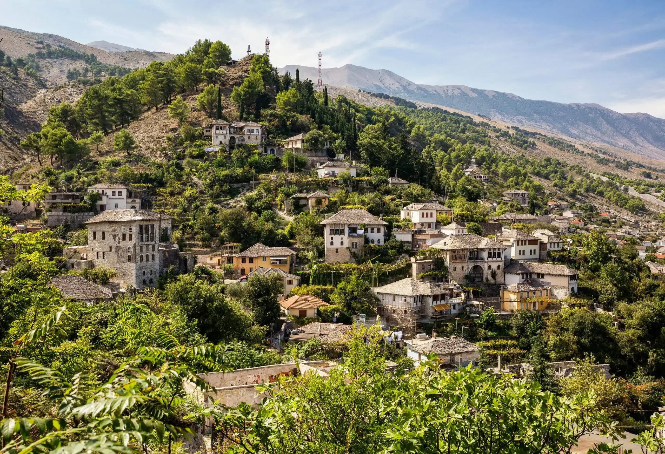 A picturesque village cascades gracefully down a slope of lush, verdant terrain.