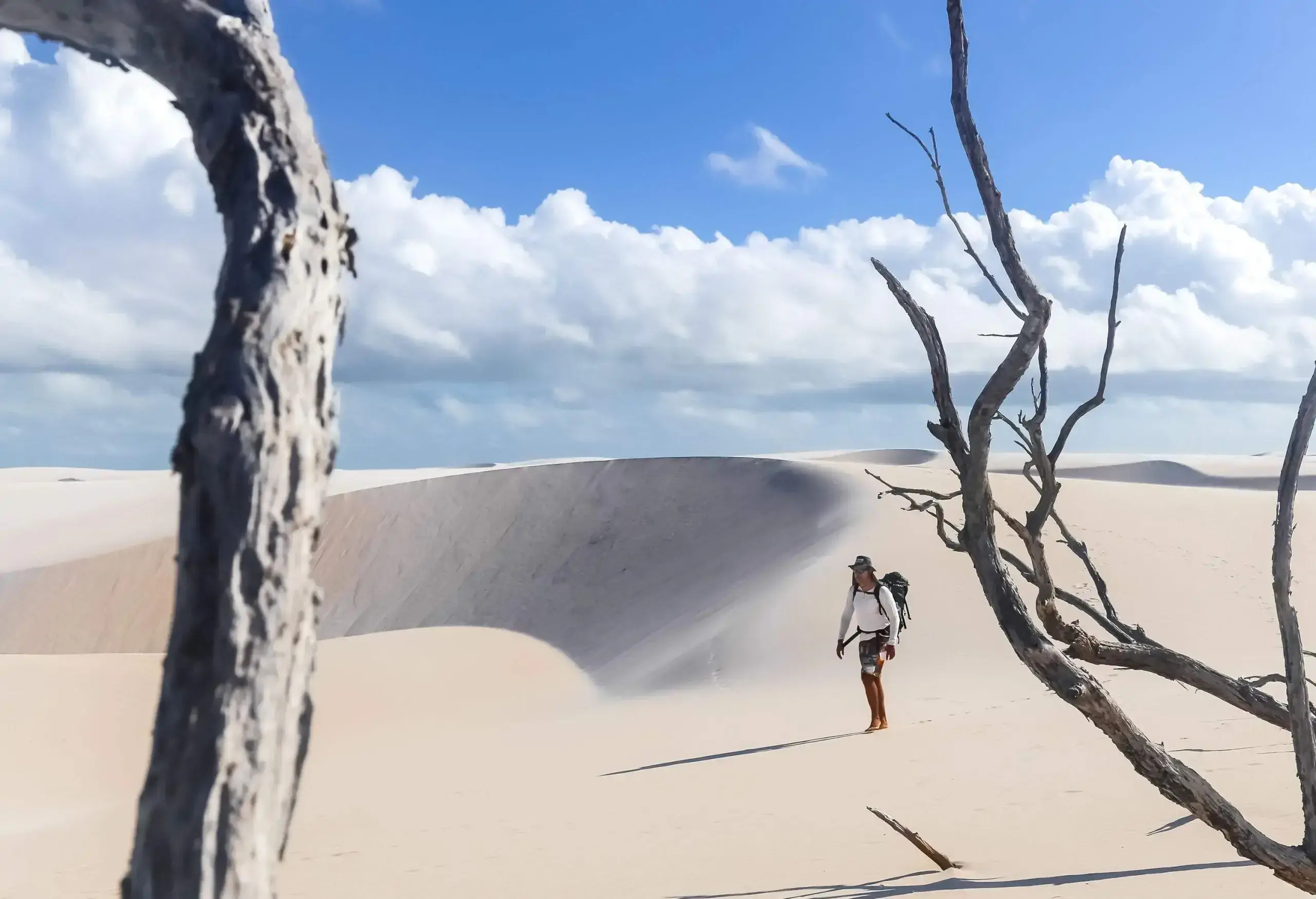 A male hiker exploring the vast rolling sand dunes.