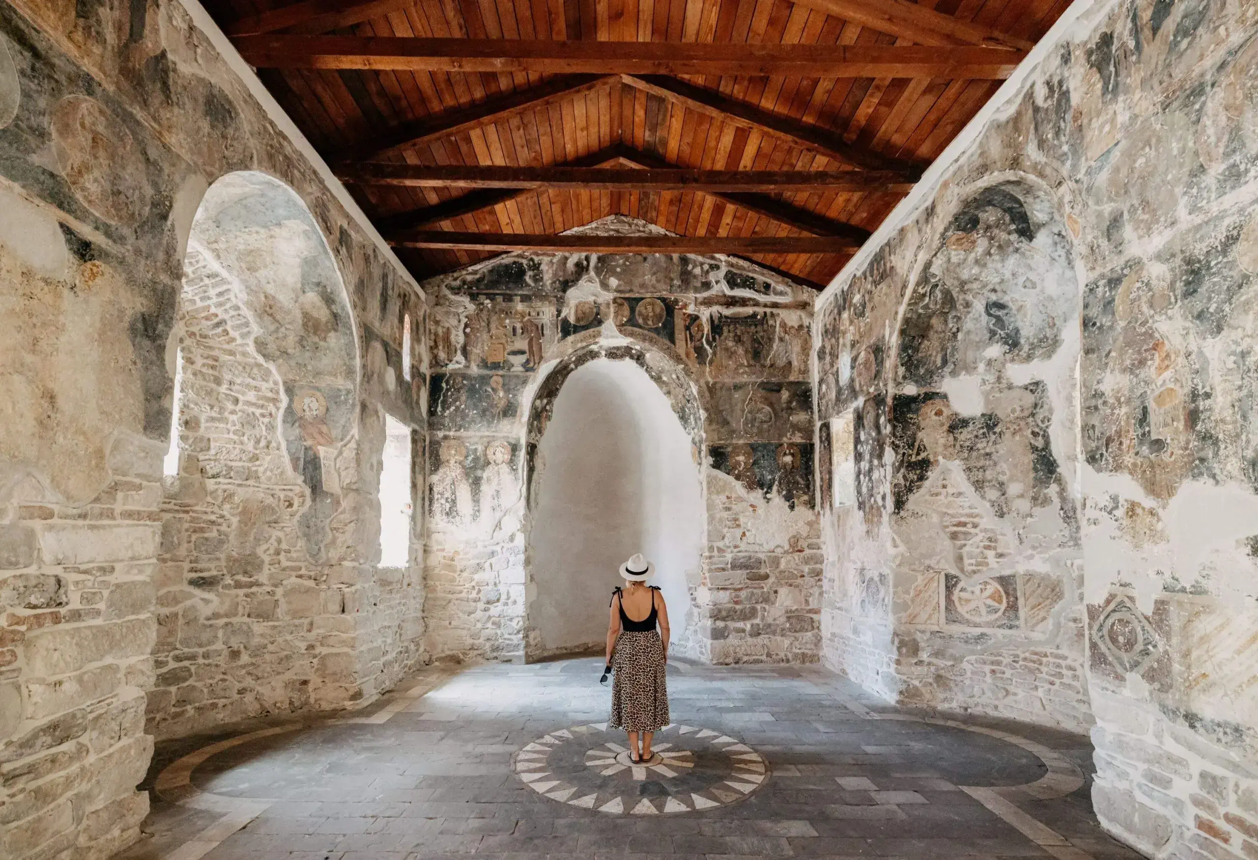 Rear view of tourist exploring ancient Ardenica Monastery during summer vacation