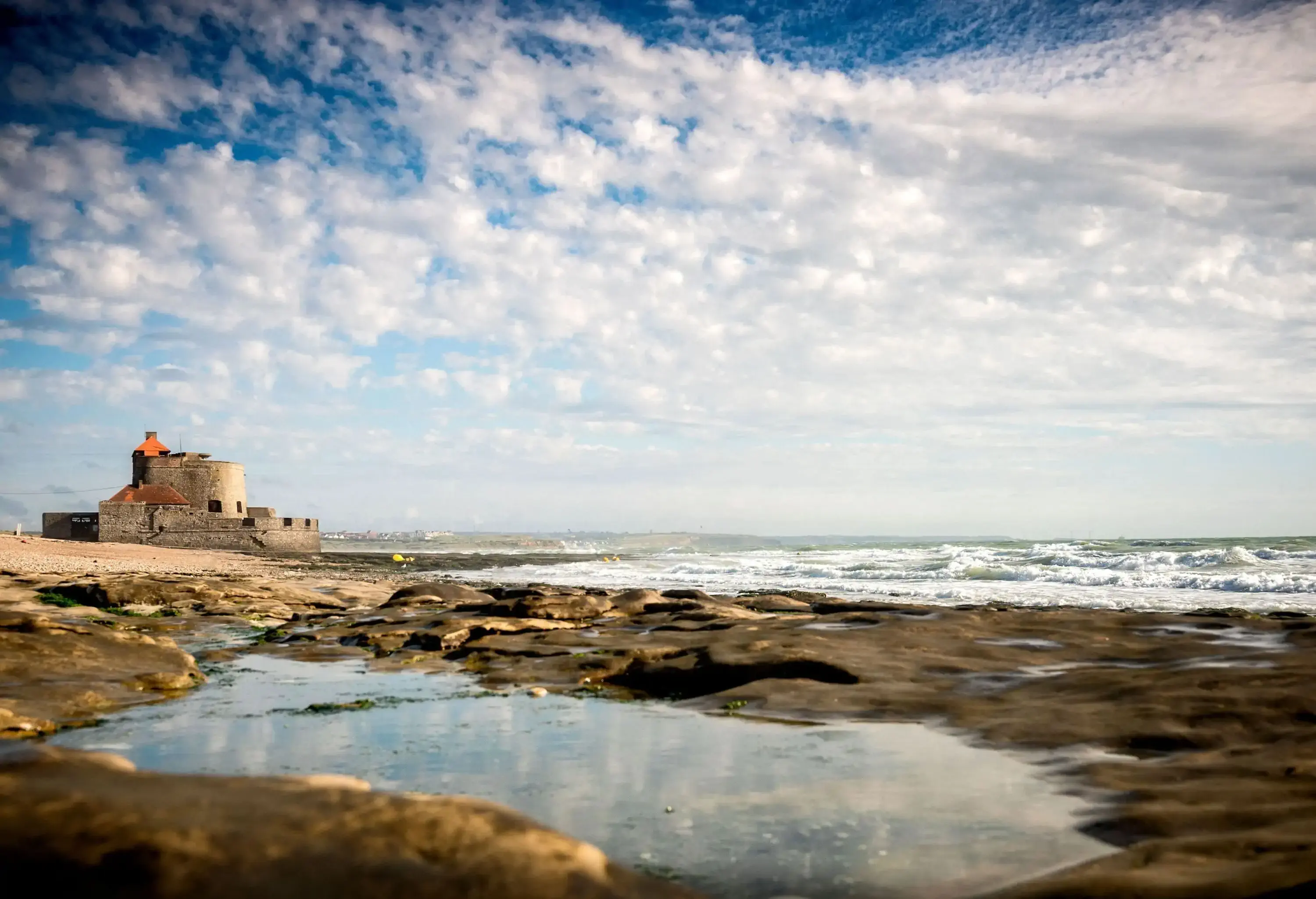 A coastal fort bordered by a horseshoe rampart overlooking the sea.