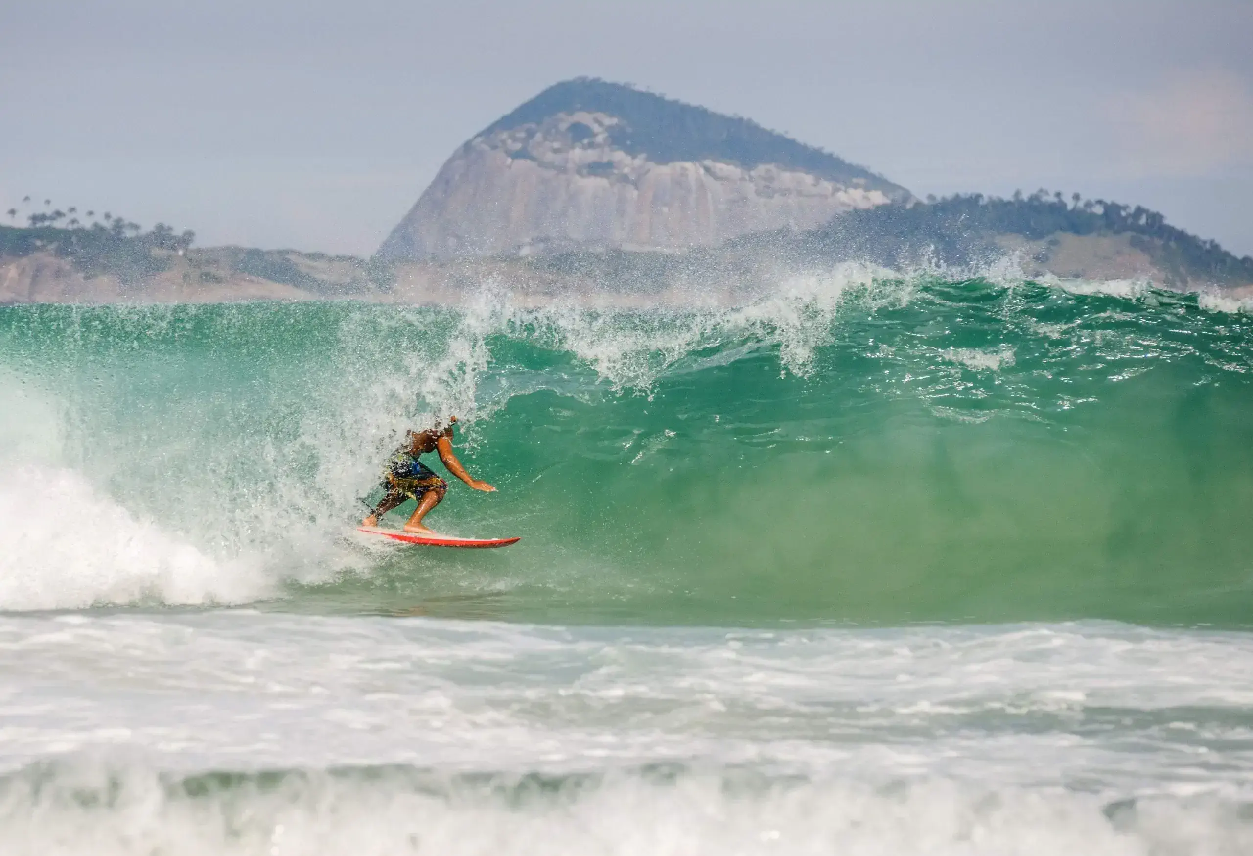 A surfer on a surfboard skillfully riding an ocean wave.
