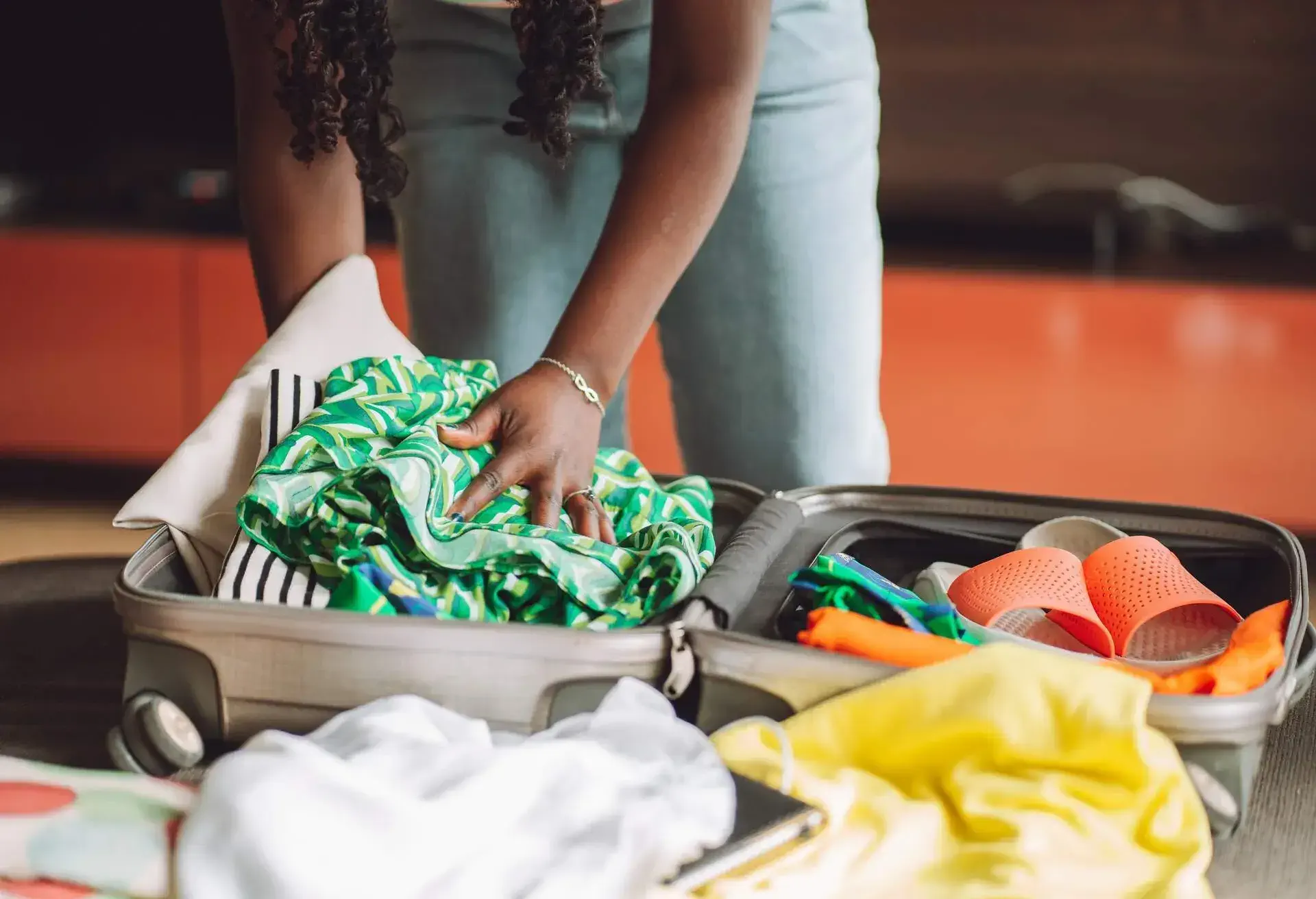 A woman packing her cloths into a suticase
