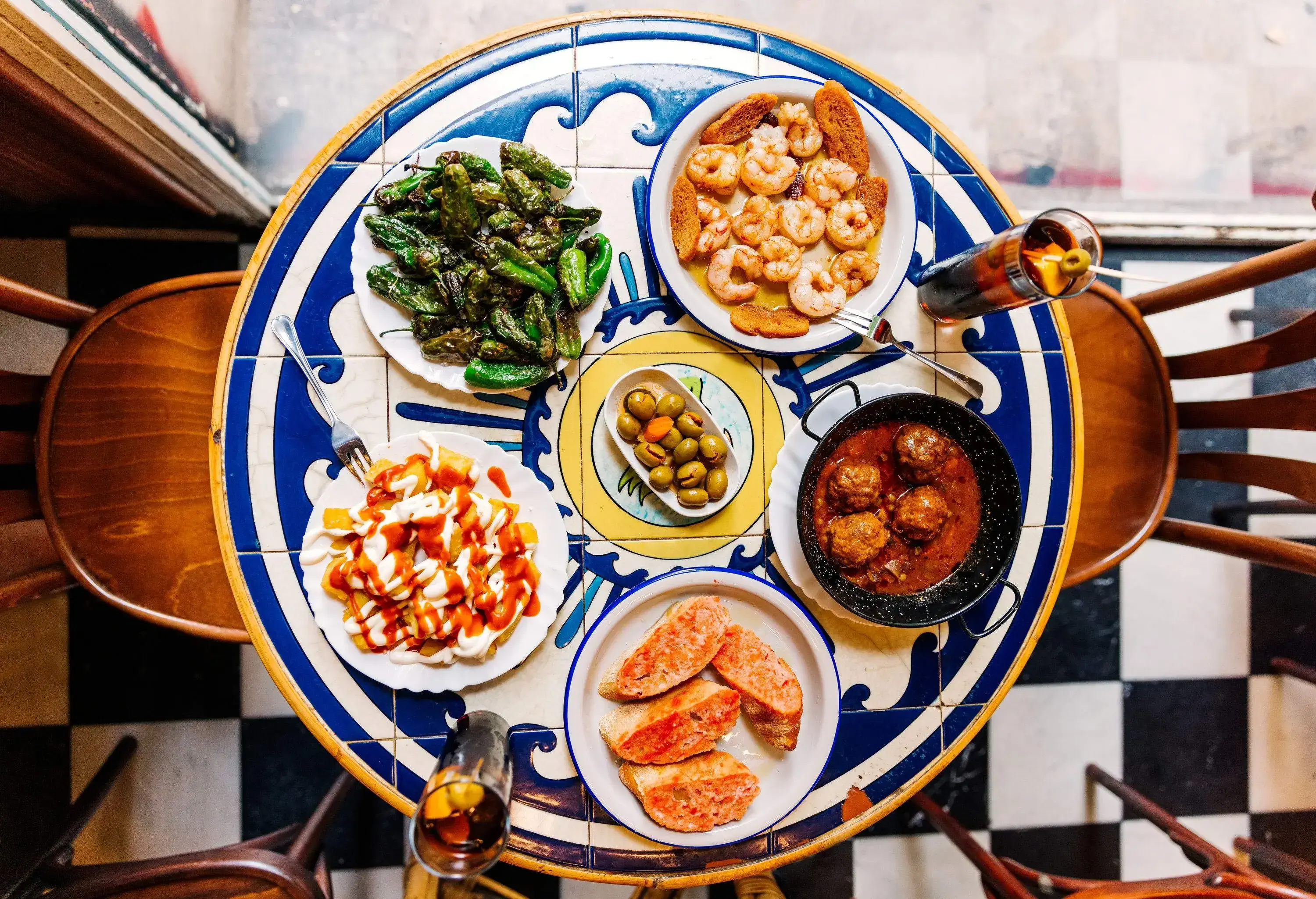 A gorgeously tiled table with a large array of Spanish tapas