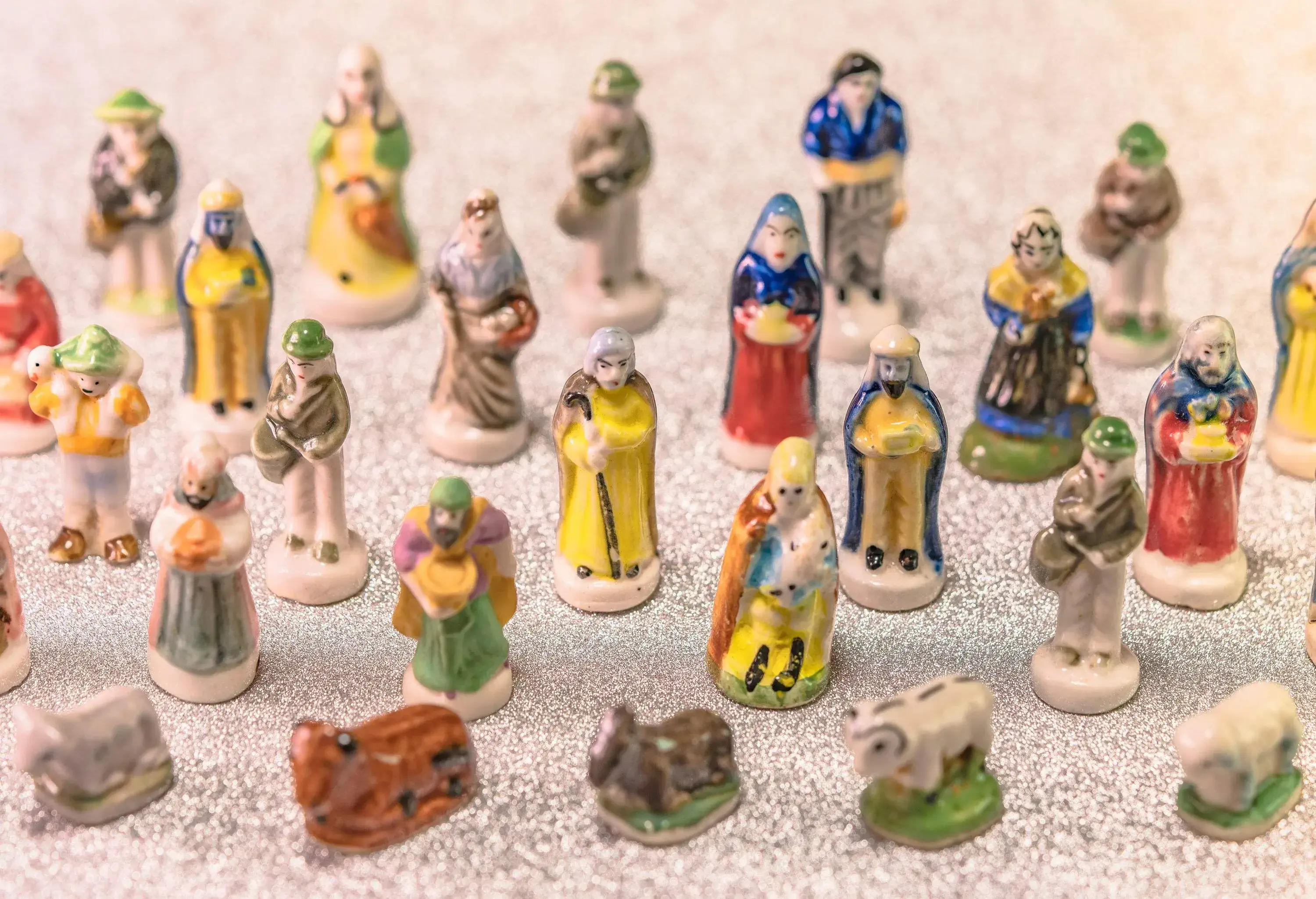 Small ceramic figurines of people and animals painted in different colours.