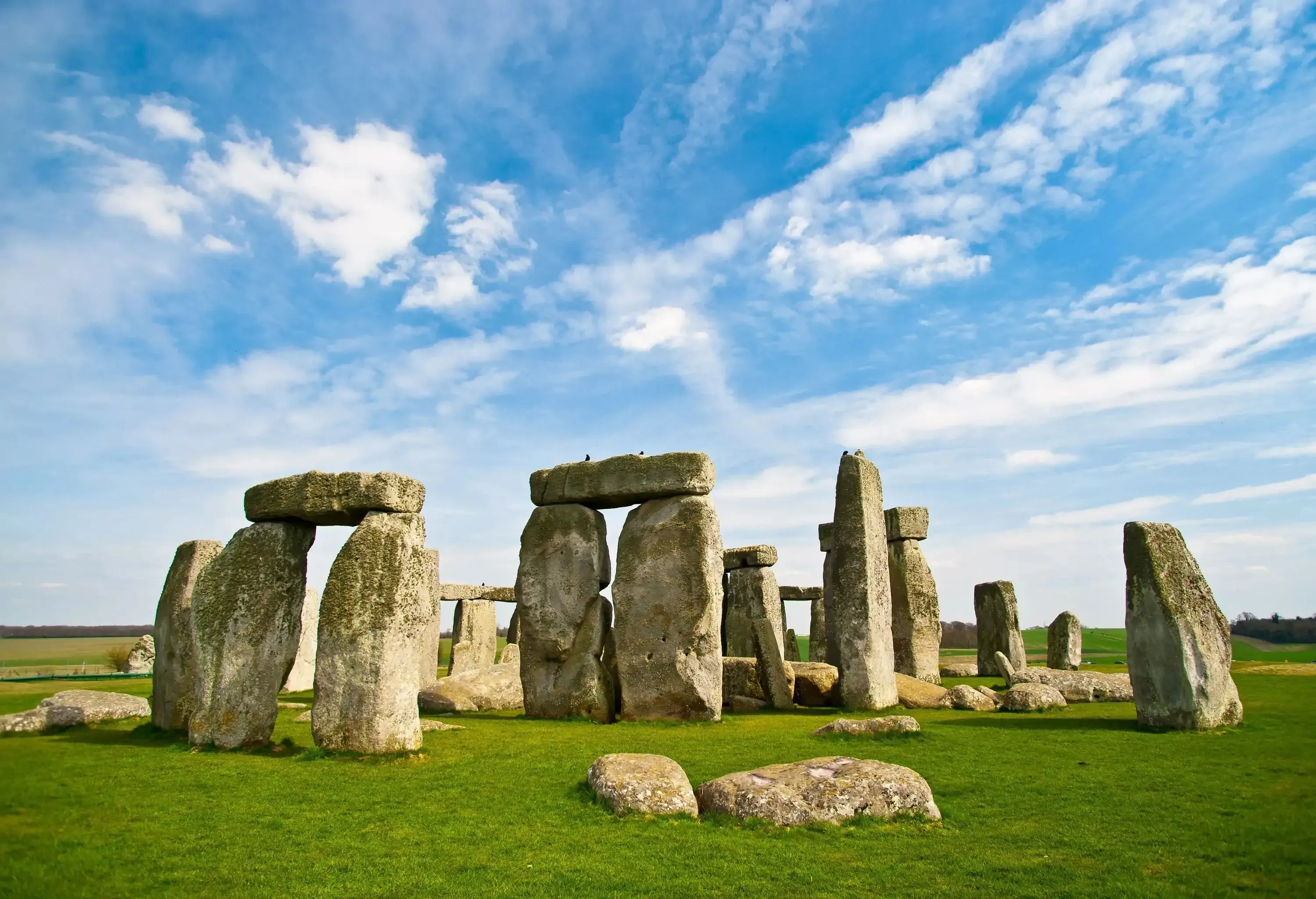 The world famous prehistoric landmark and UNESCO World Heritage Site on Salisbury Plain, Wiltshire, England. A beautiful blue sky with fluffy clouds provides copy space above while bright green grasses below grab the viewer's attention.