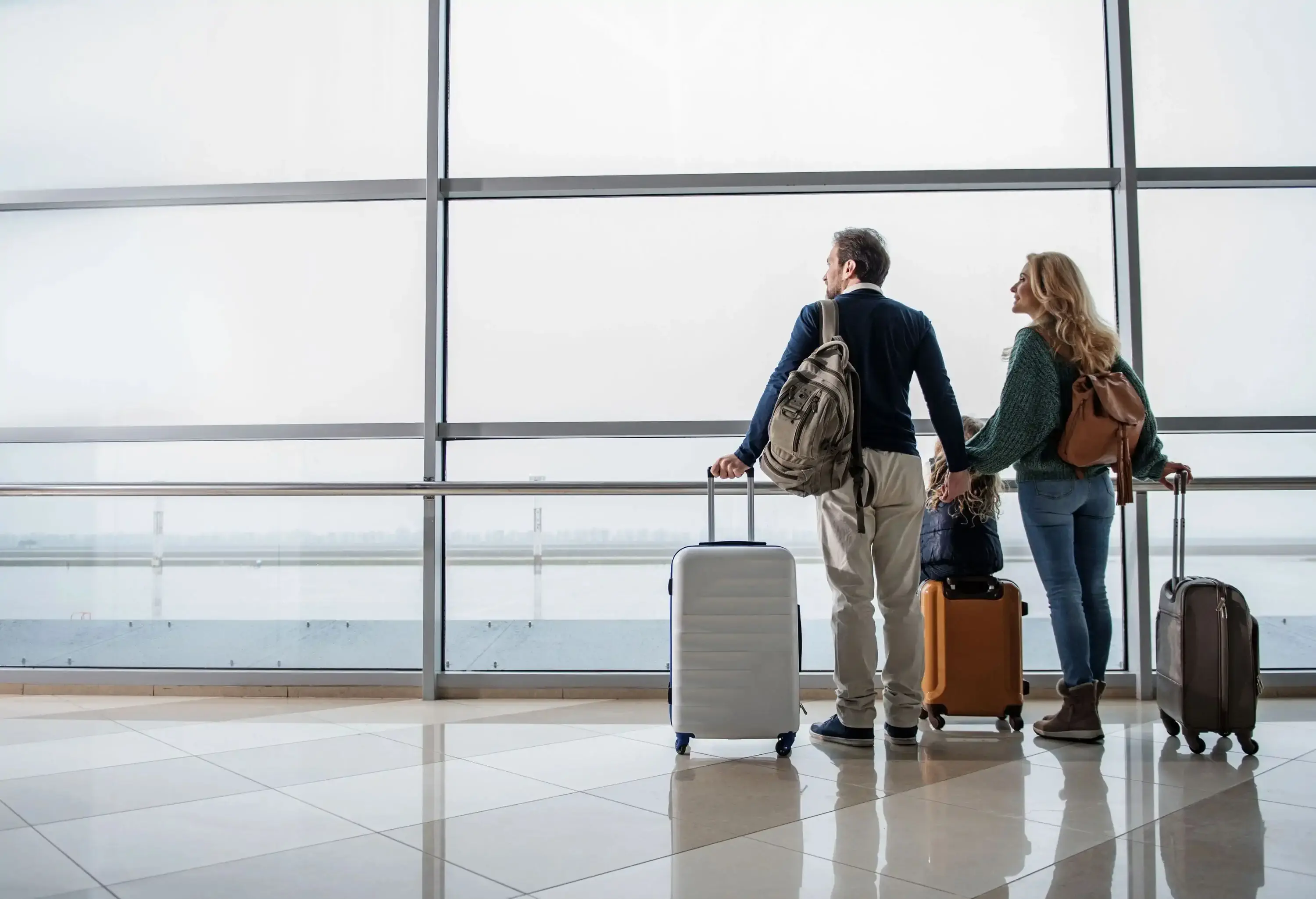 A family waiting with their luggage at the airport