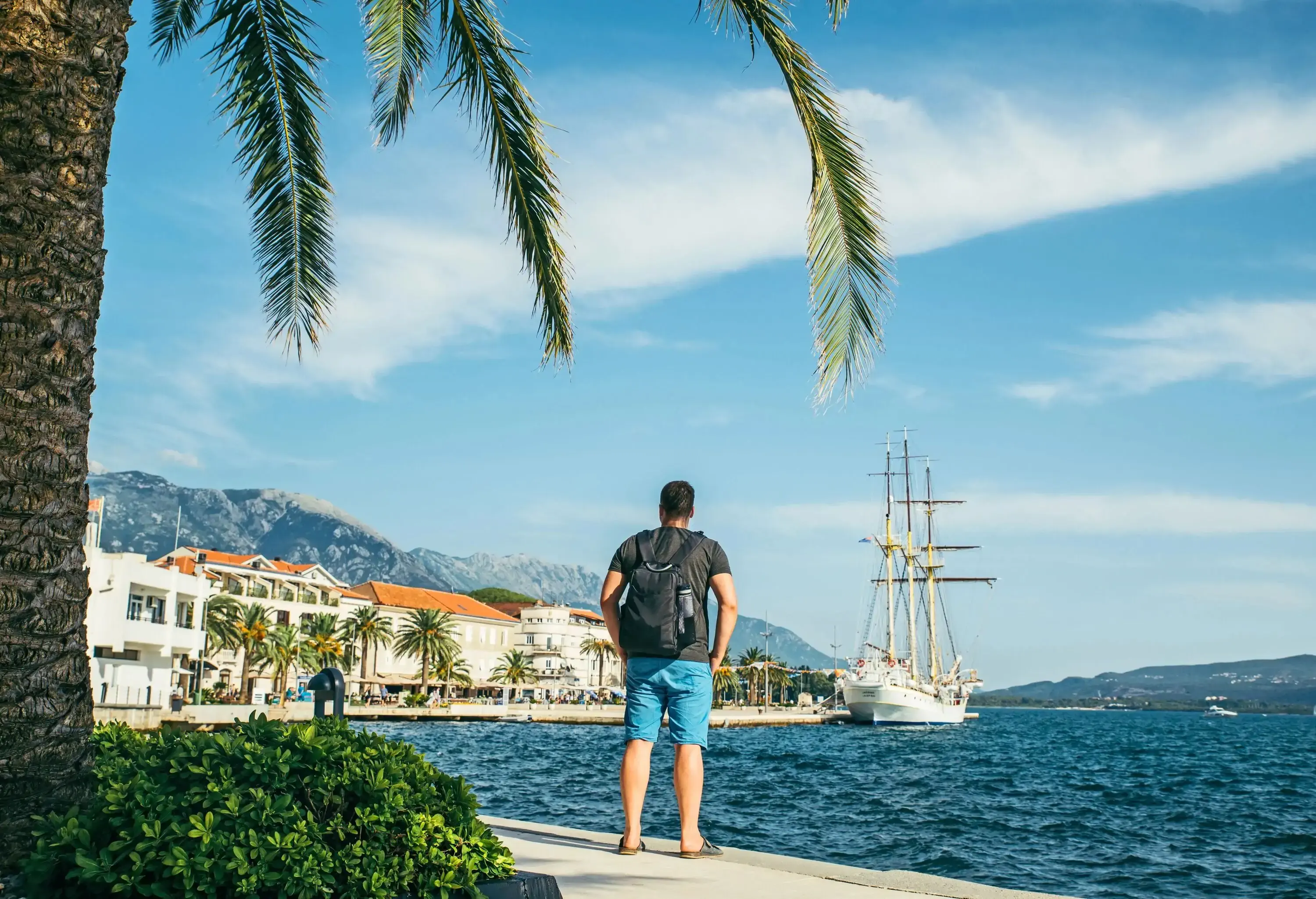 man standing at seaside with beautiful view of bay with big ship. summer time.; Shutterstock ID 1176614941