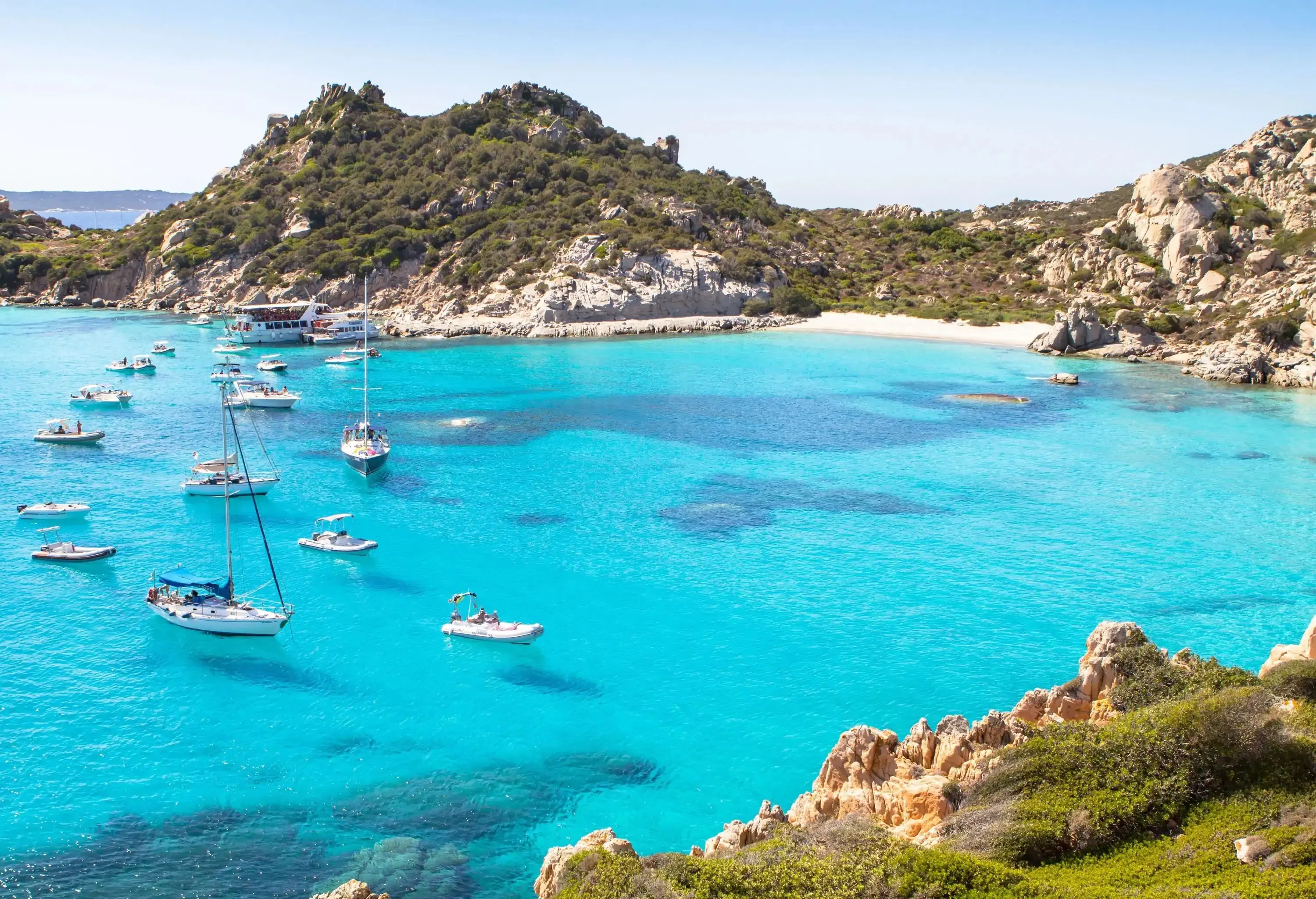 Sailboats floating flawlessly across the bay's pristine turquoise waters.