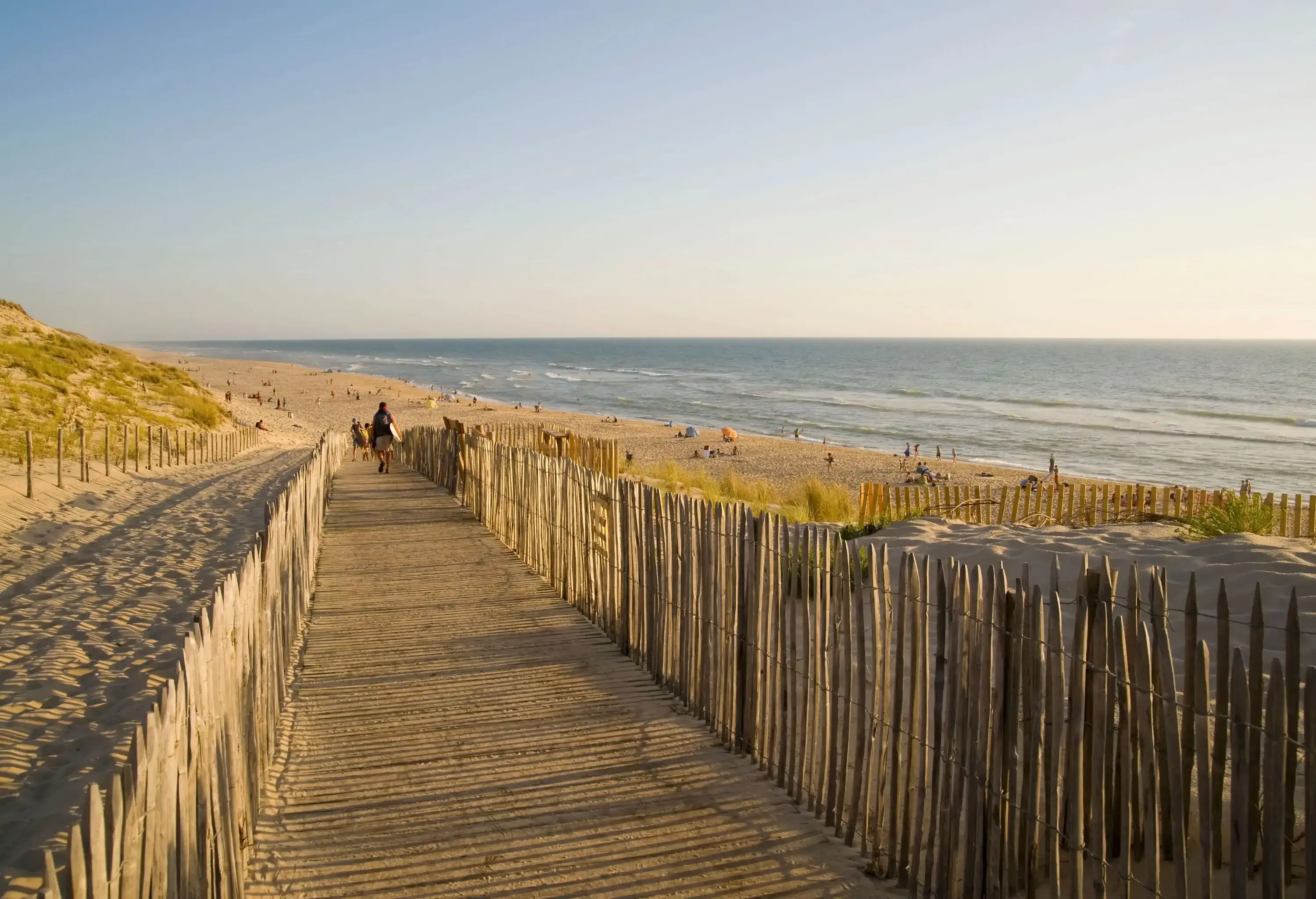 Wooden walkway to a wide sandy beach at golden hour