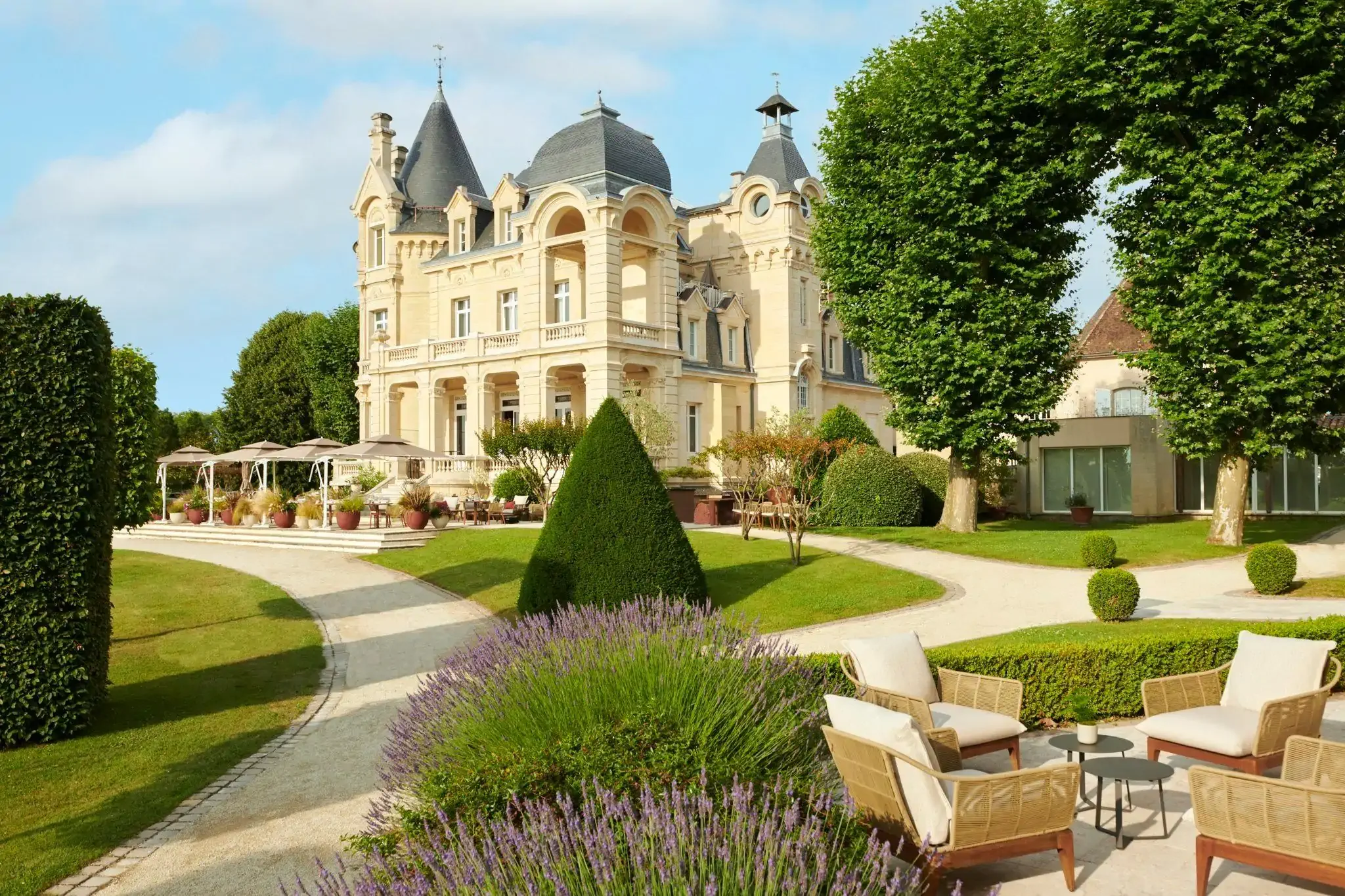 Exterior of a chateau and its manicured gardens at golden hour