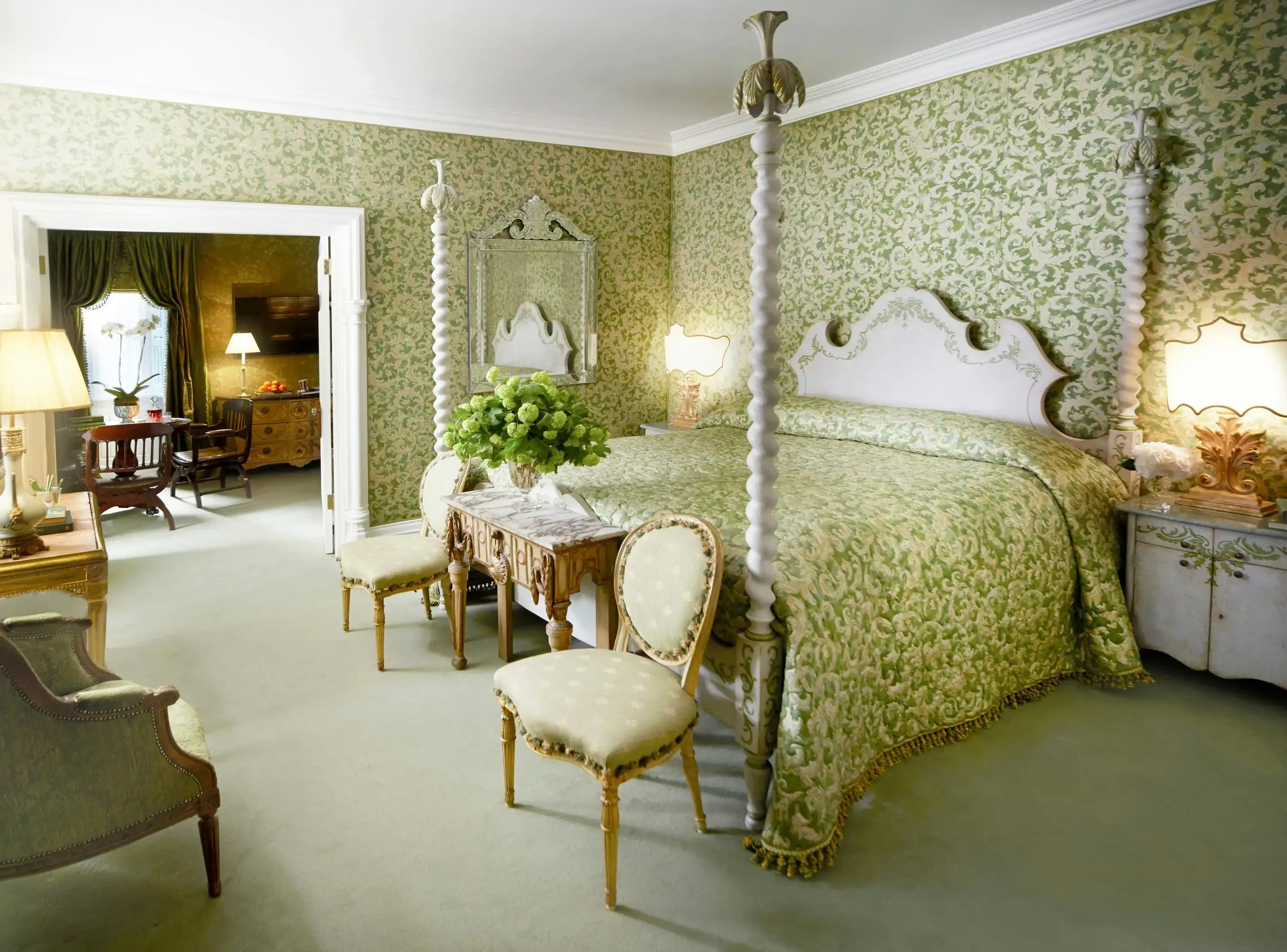 Hotel room in traditional style with four-poster bed and green floral wallpaper