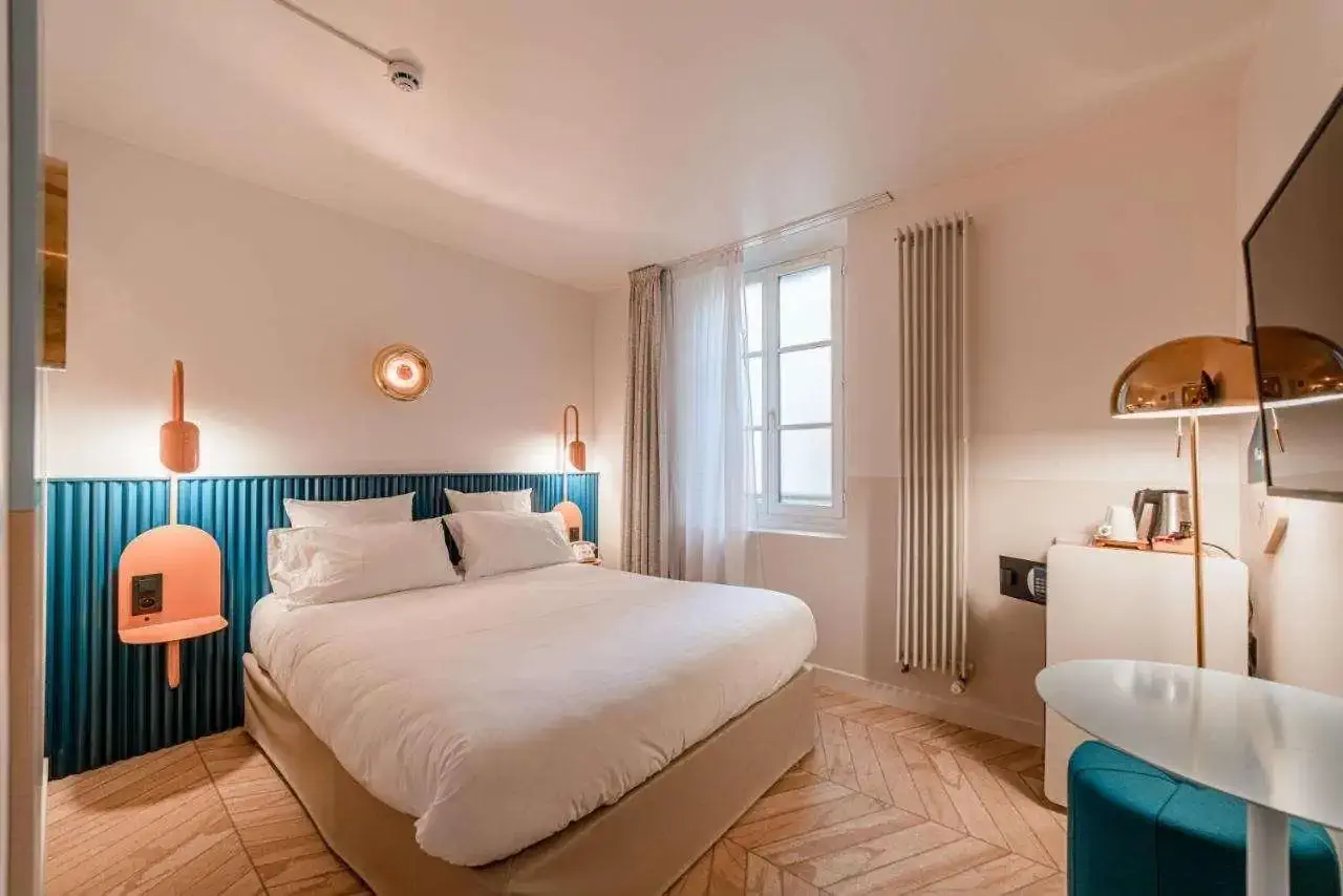 A hotel room with turquoise accents and white bed linen