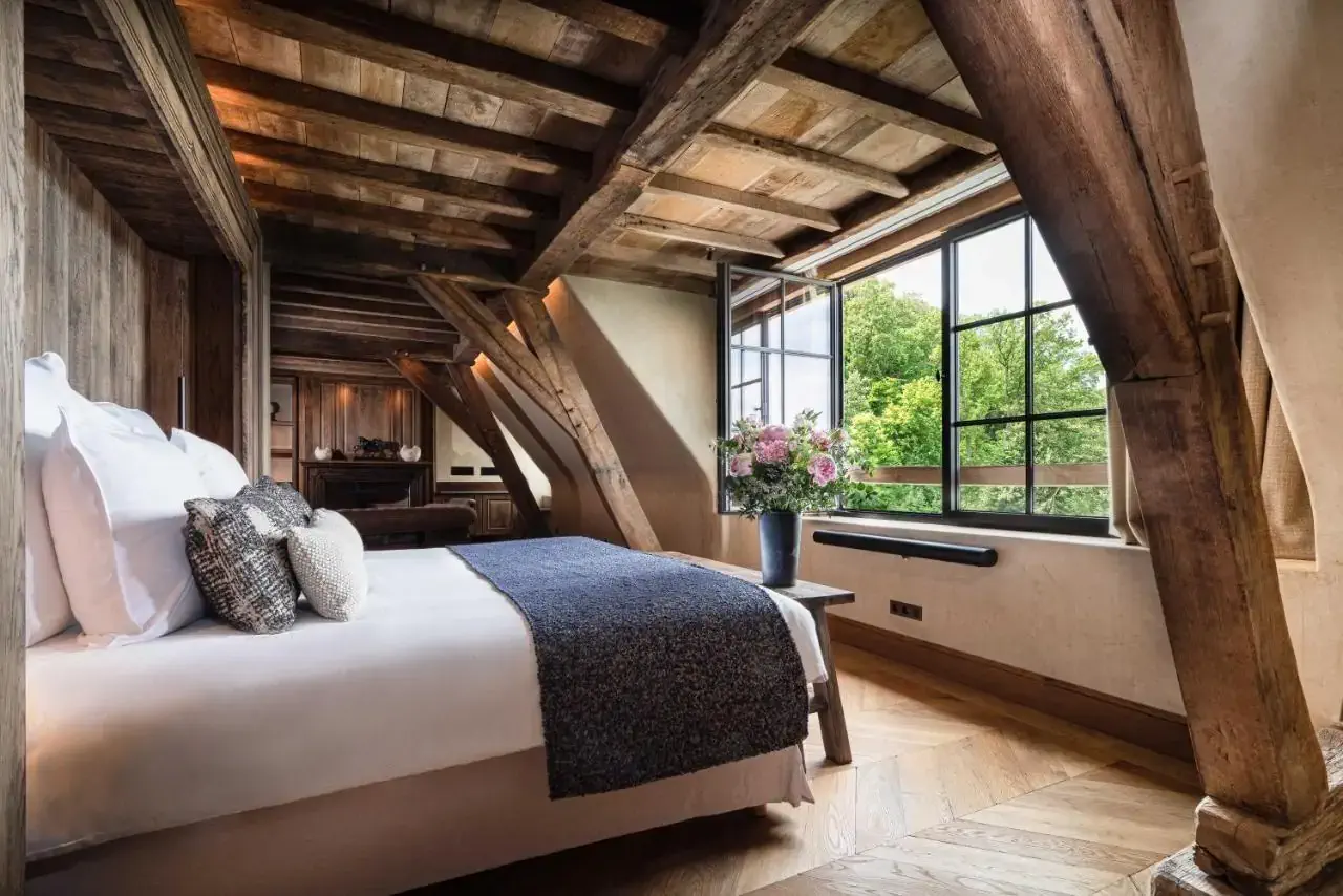 A rustic elegant hotel room in the attic with wooden timber exposed beams