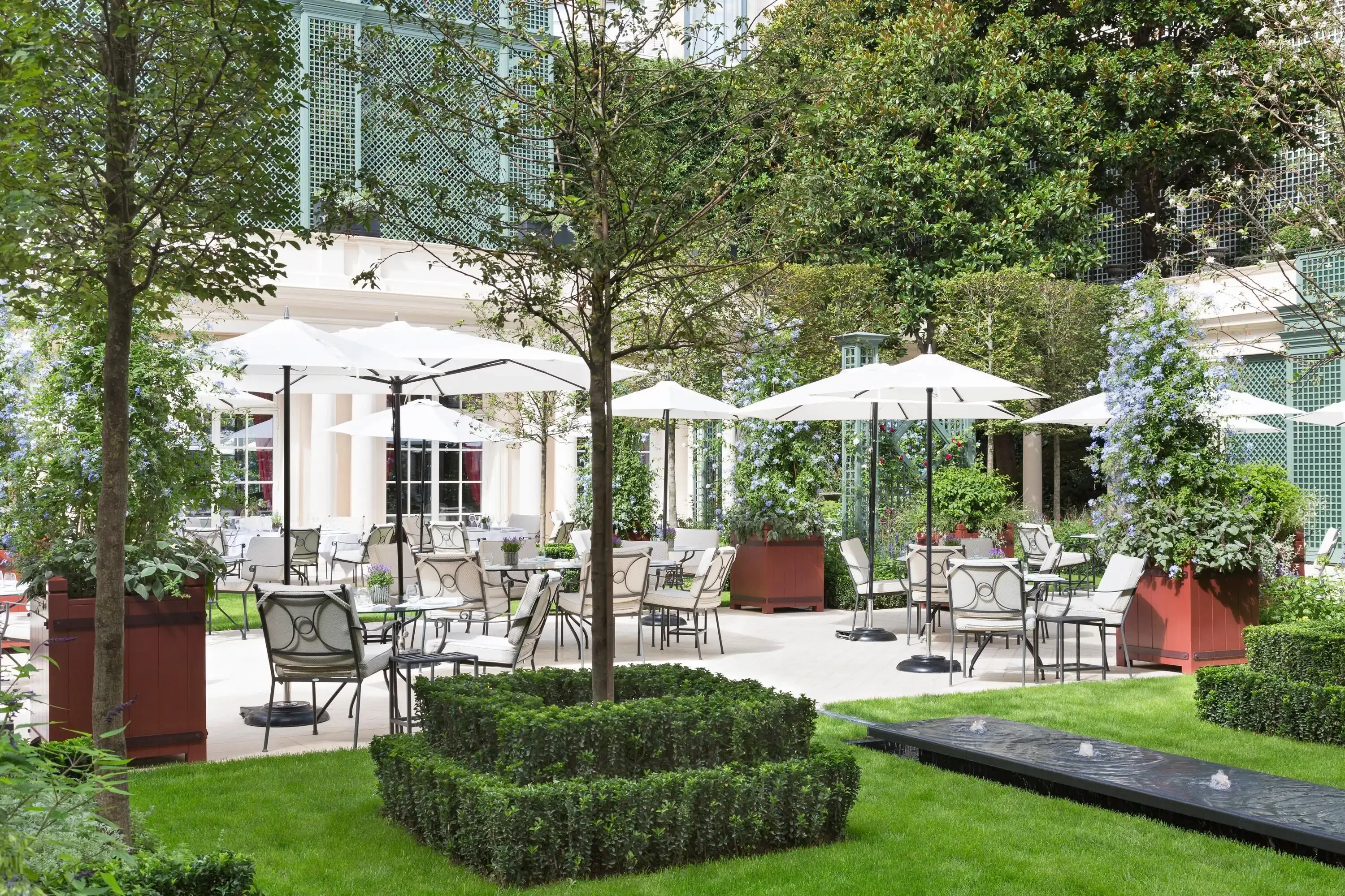 Garden of a luxury hotel with tables and parasols on a summer day