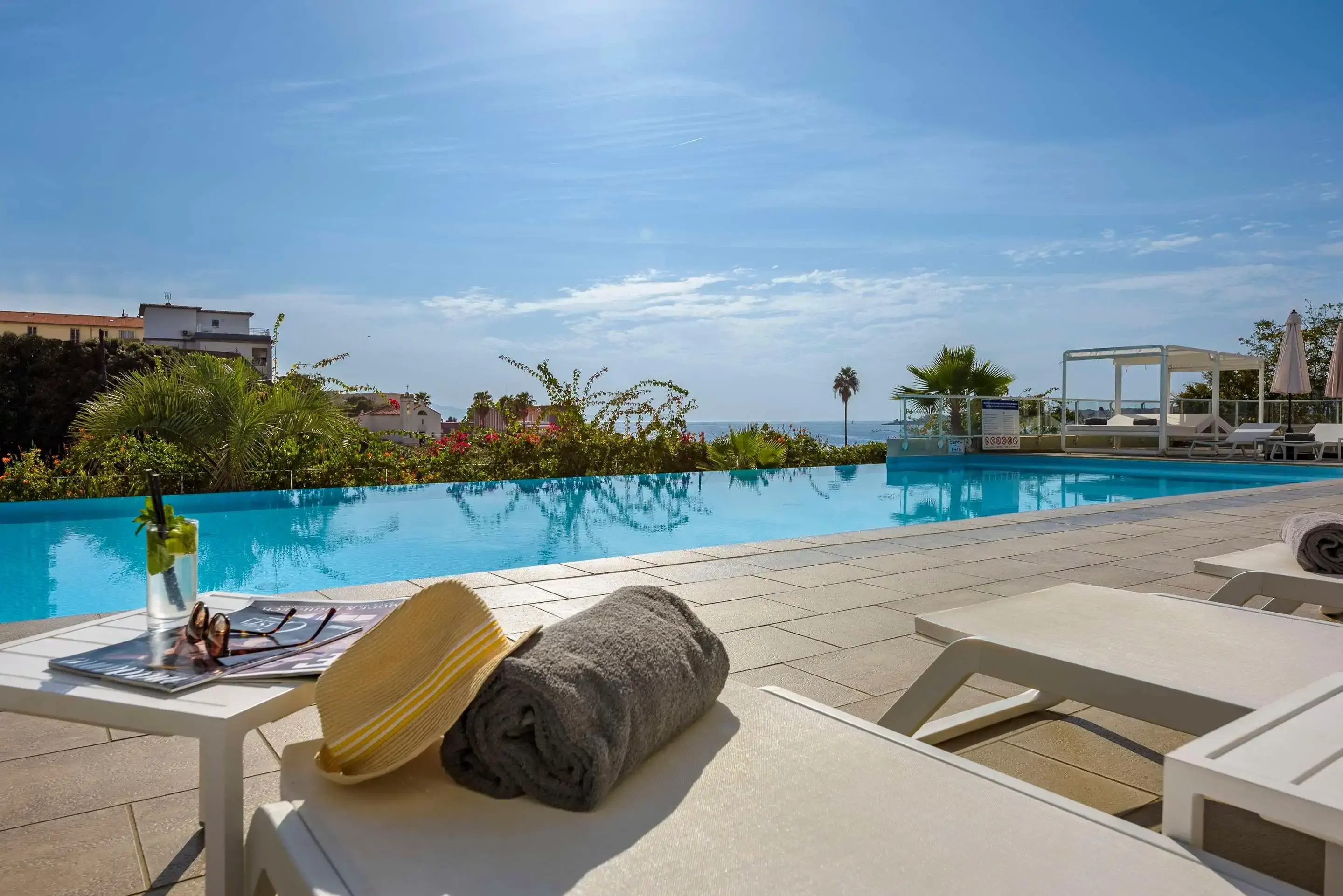 View of the sea from the side of a large swimming pool on a summer day