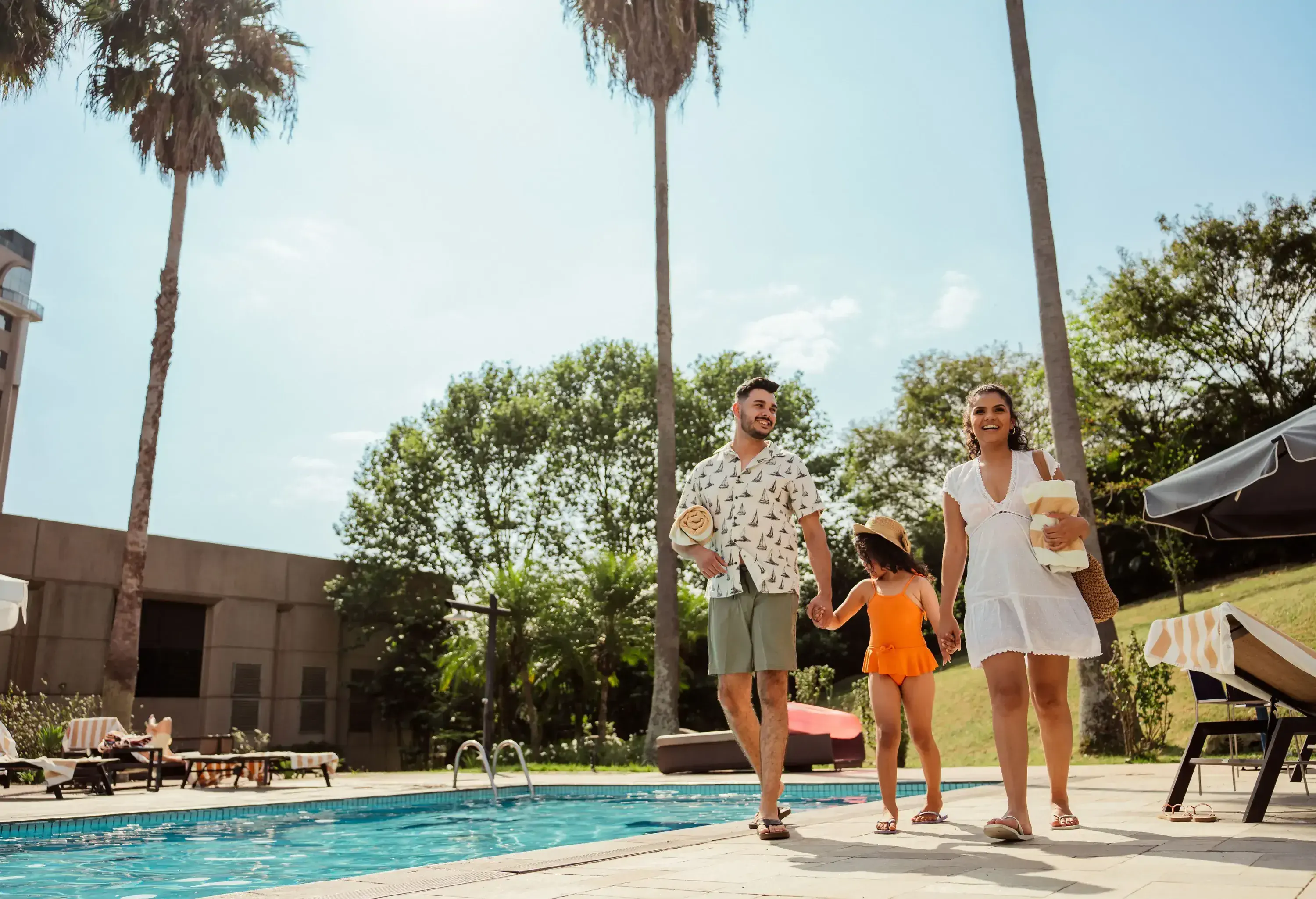Family arriving to enter the pool at the luxury hotel