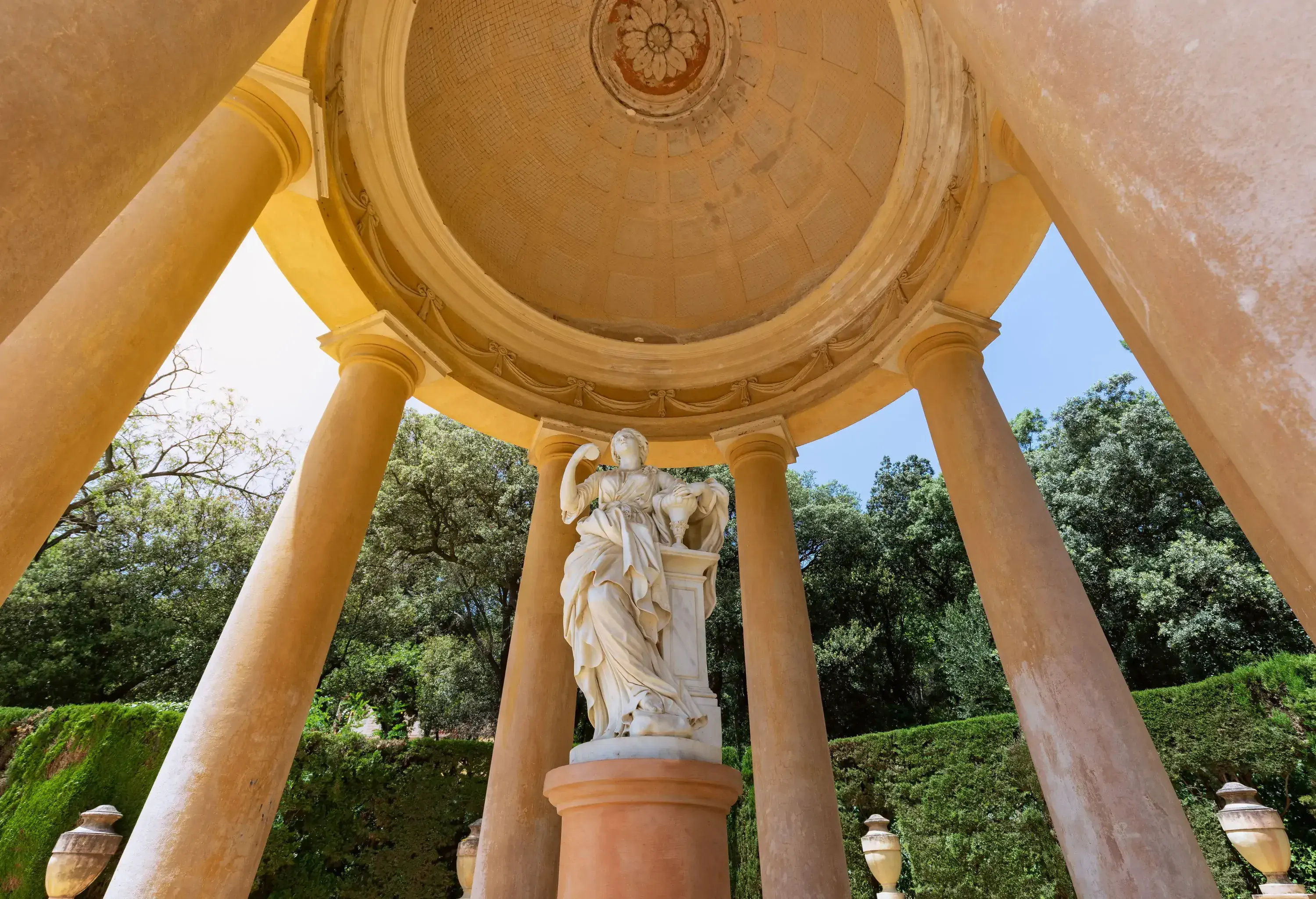 A gazebo with a detailed sculpture of a woman standing in the middle.