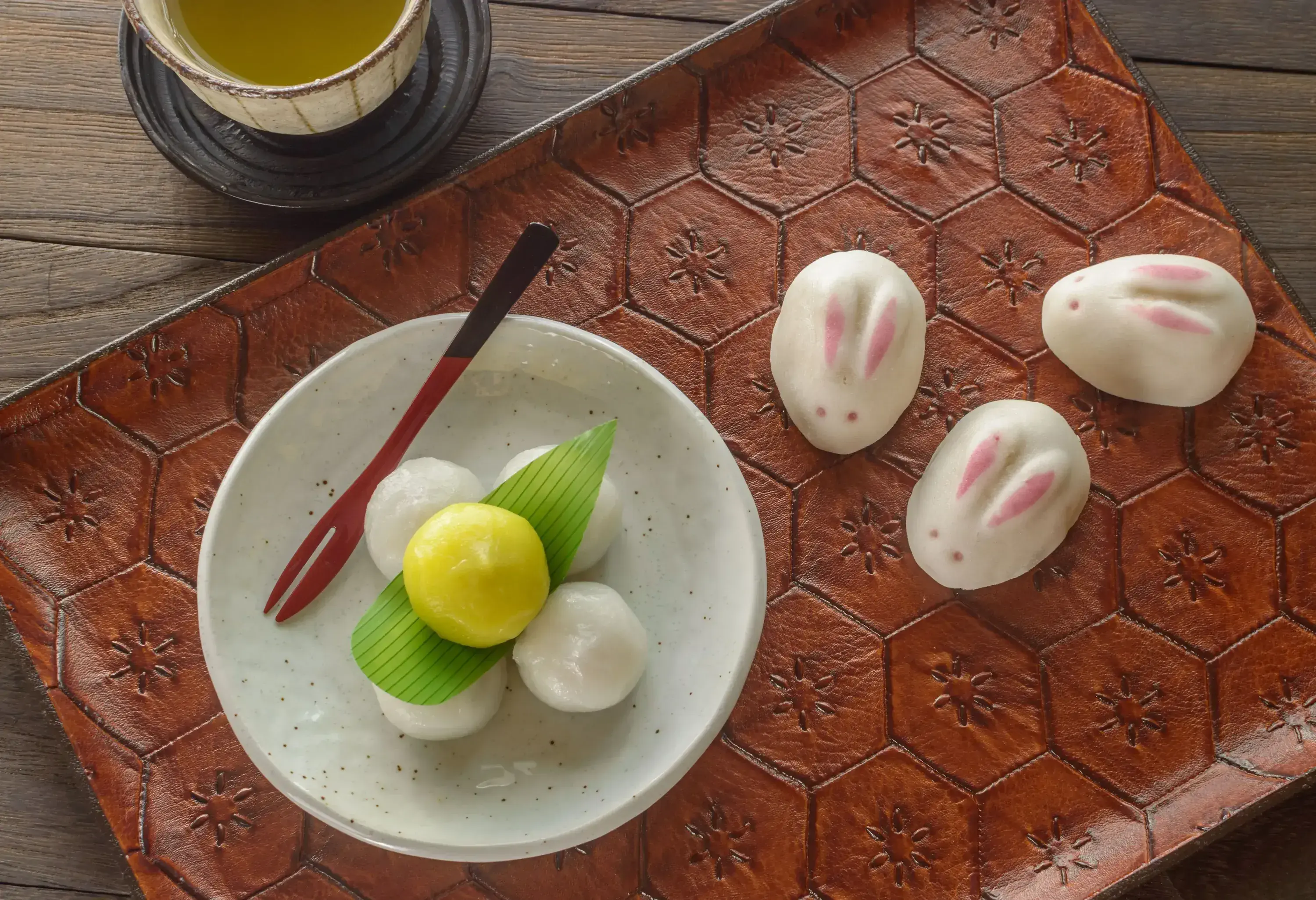 Typical Tsukimi dango and rabbit-shaped steamed buns served on a tray with a glass of tea.